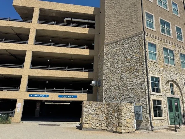 Stone-clad facade with multiple windows and a green double-door entrance