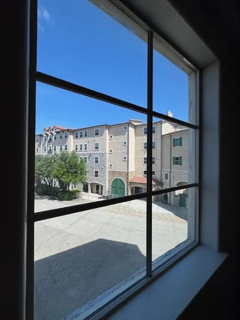 Window with muntins overlooking a paved courtyard