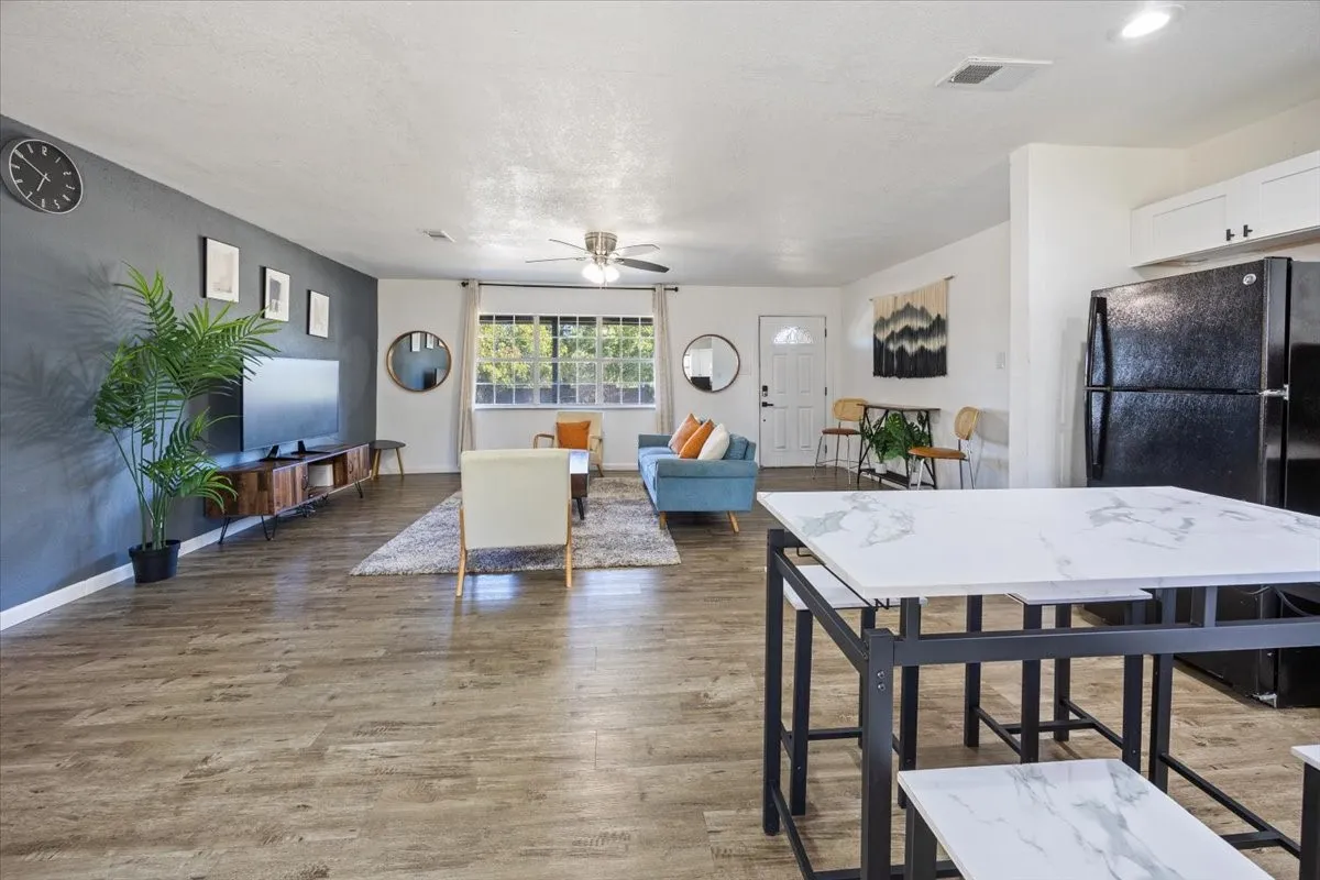 Open-concept living space featuring wood-finish flooring, a contemporary ceiling fan, and recessed lighting