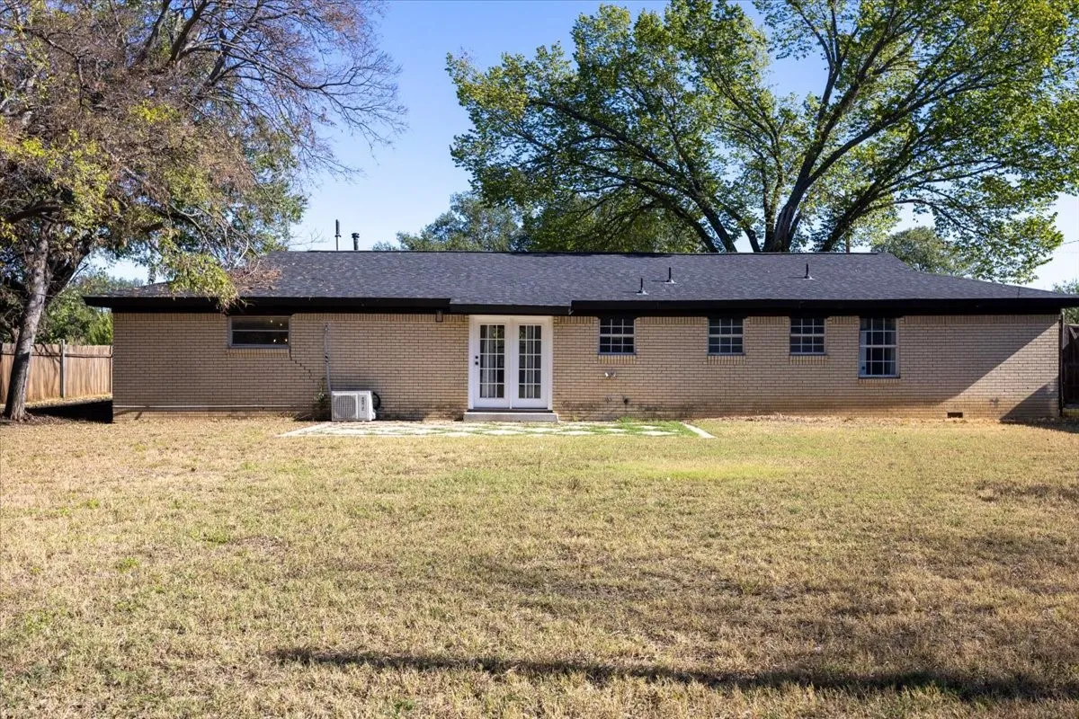 Back of house with patio and large, fenced backyard.