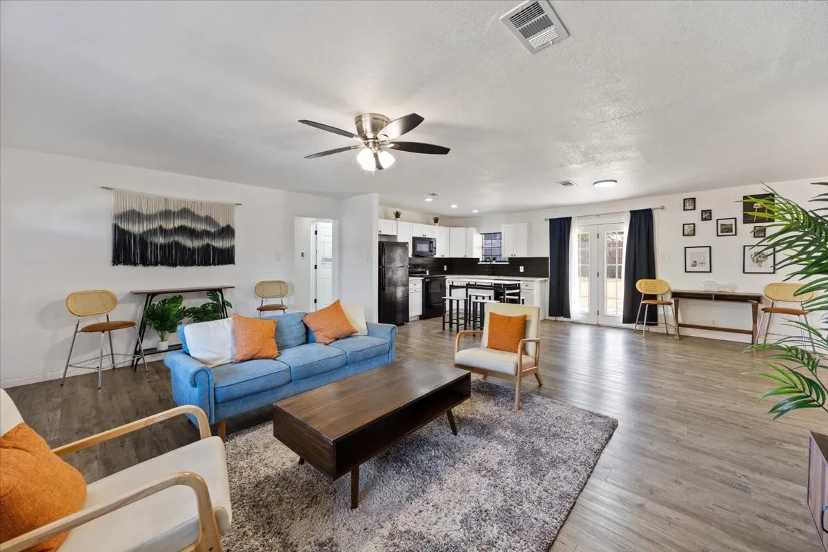 Another view of the open living room and kitchen with french doors to the backyard.