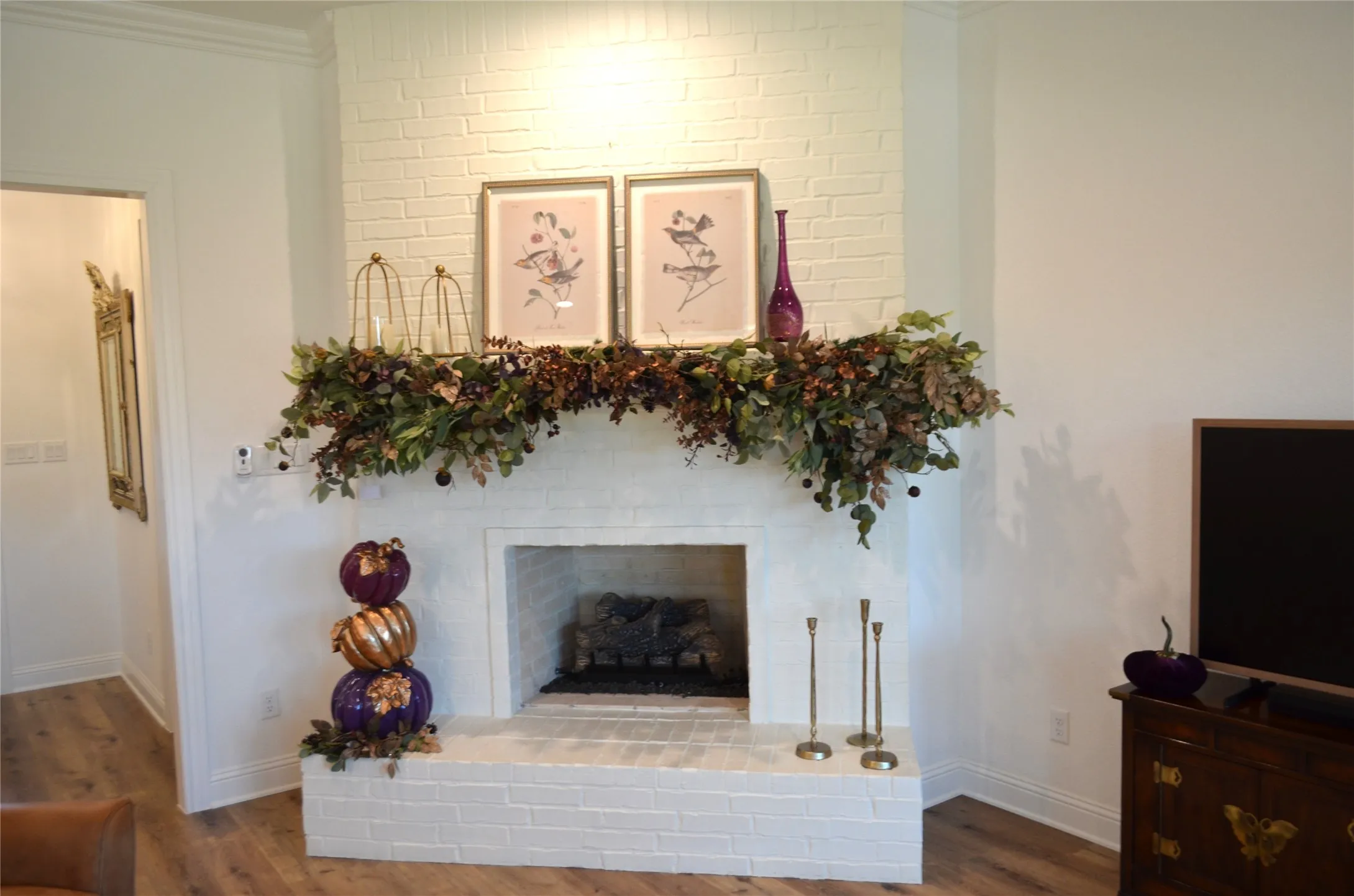 White brick fireplace with an integrated hearth, featuring a dark metal firebox insert