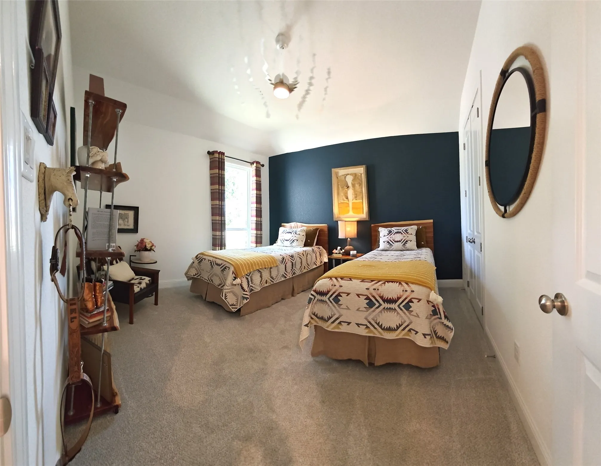 Vaulted ceiling with a ceiling fan, plush carpet flooring, window with plaid curtains, and a dark accent wall