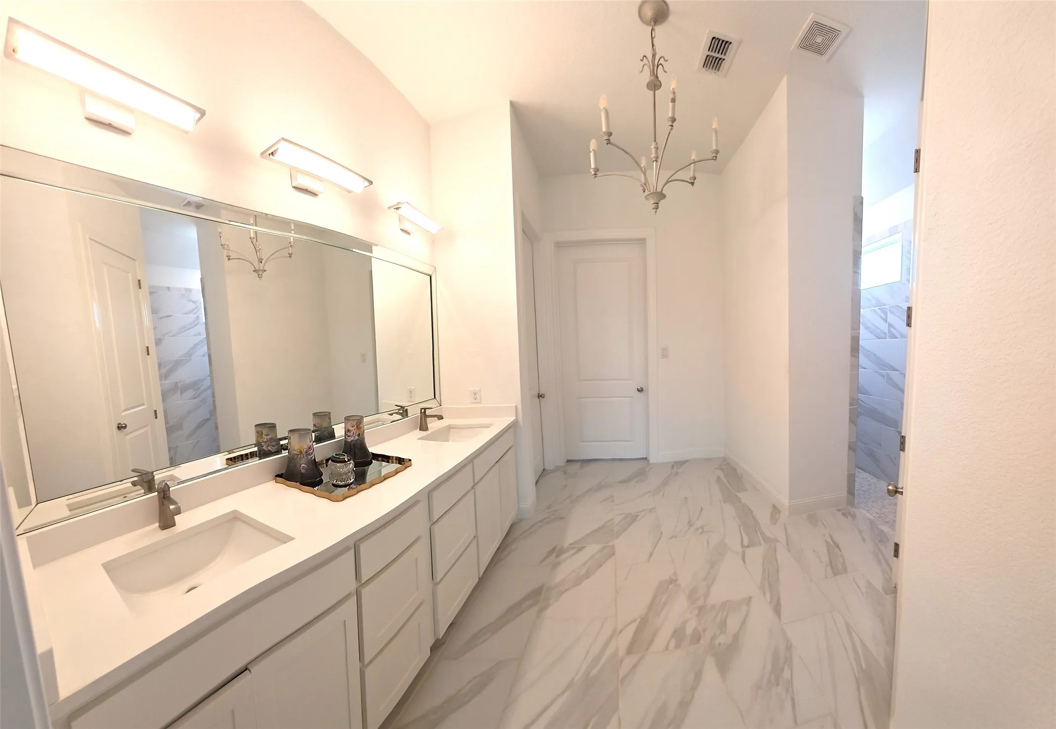 Dual vanity with white cabinetry, integrated sinks, and polished chrome faucets