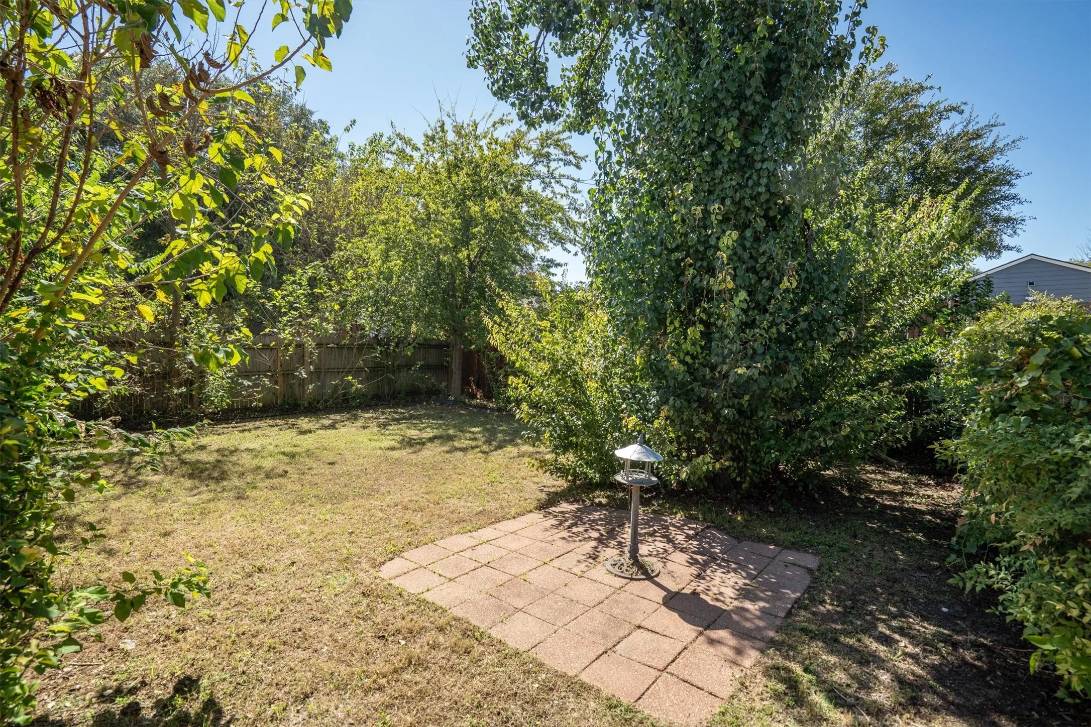Expansive backyard with a paver patio and established landscaping