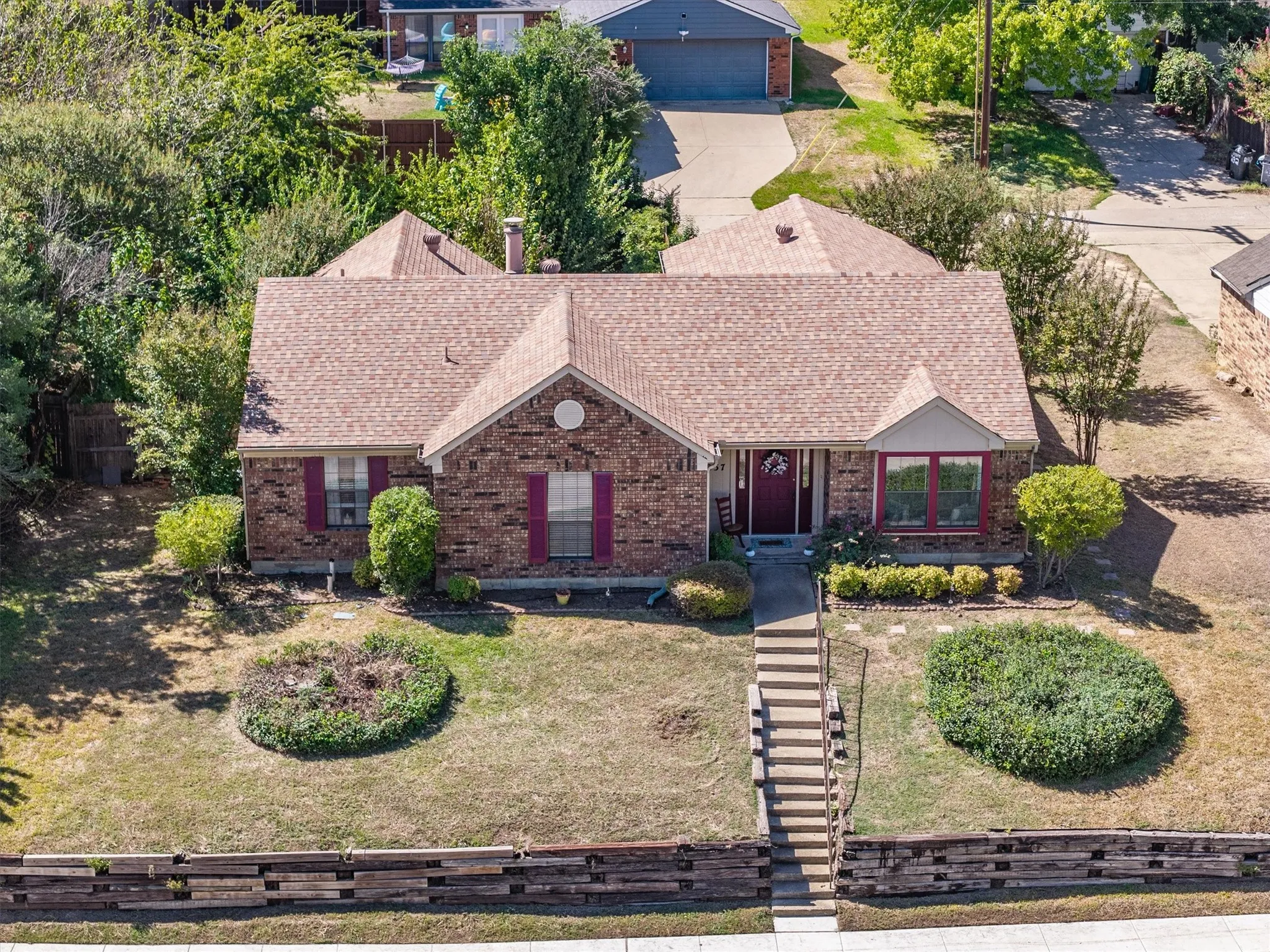 Brick exterior with a peaked roof, featuring a bay window and decorative shutters