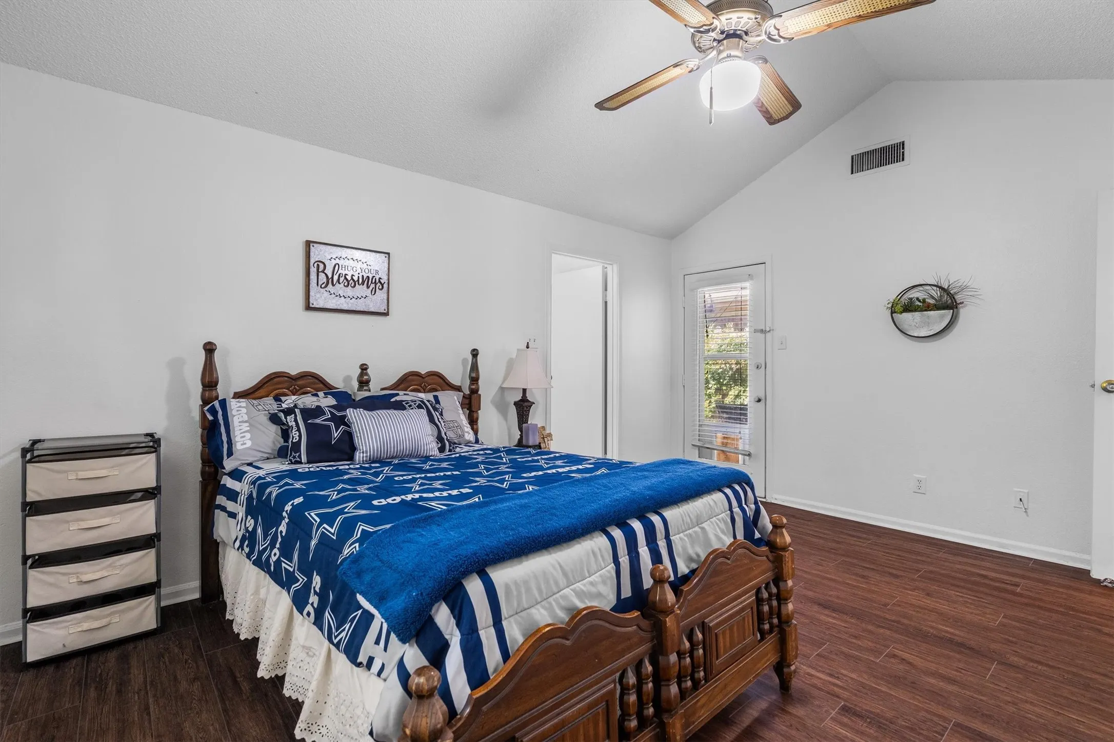 Vaulted ceiling with an attached ceiling fan, wood-finish flooring, and a glass-paneled​​‌​​​​‌​​‌‌​‌‌​​​‌‌​‌​‌​‌​​​‌​​ door