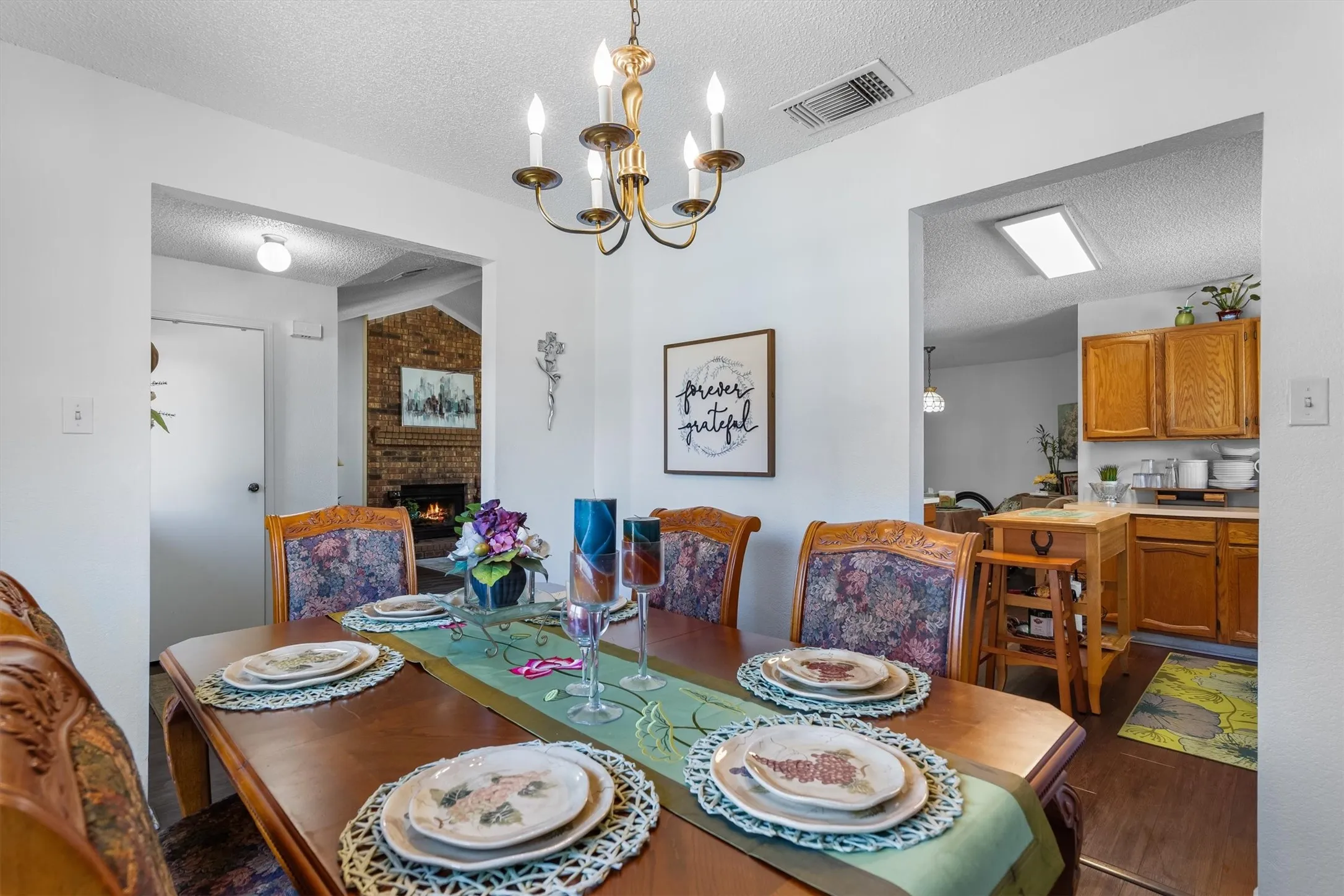 Dining area with a chandelier, wood-finish flooring, and painted white walls