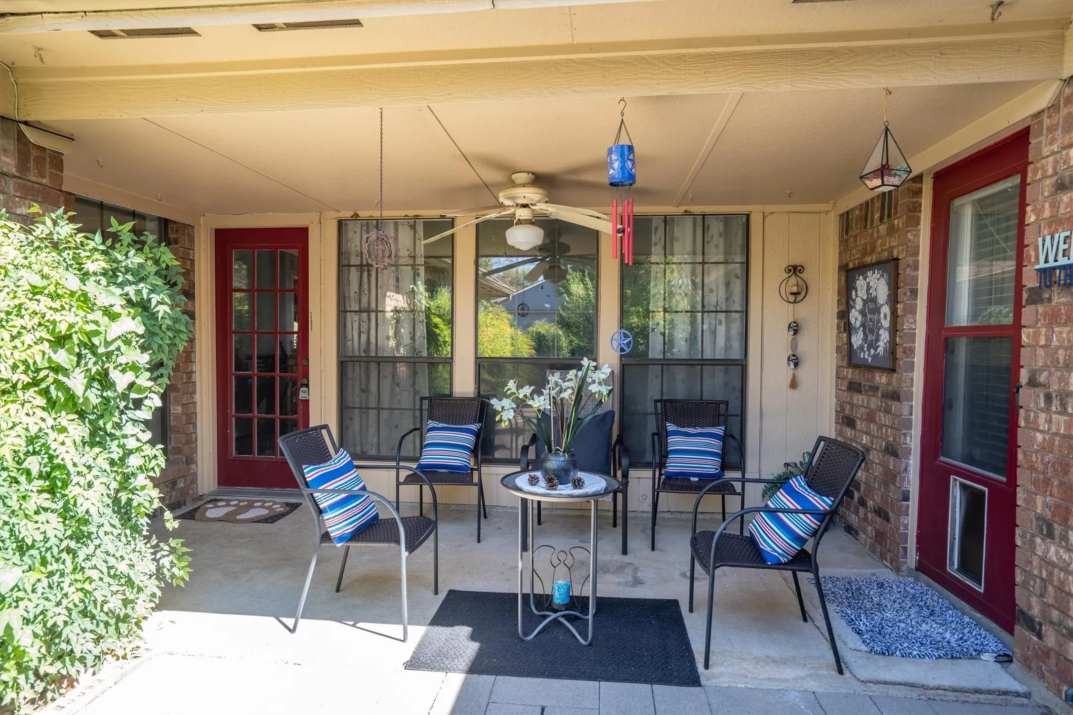 Covered patio with a ceiling fan, concrete flooring, and brick exterior walls