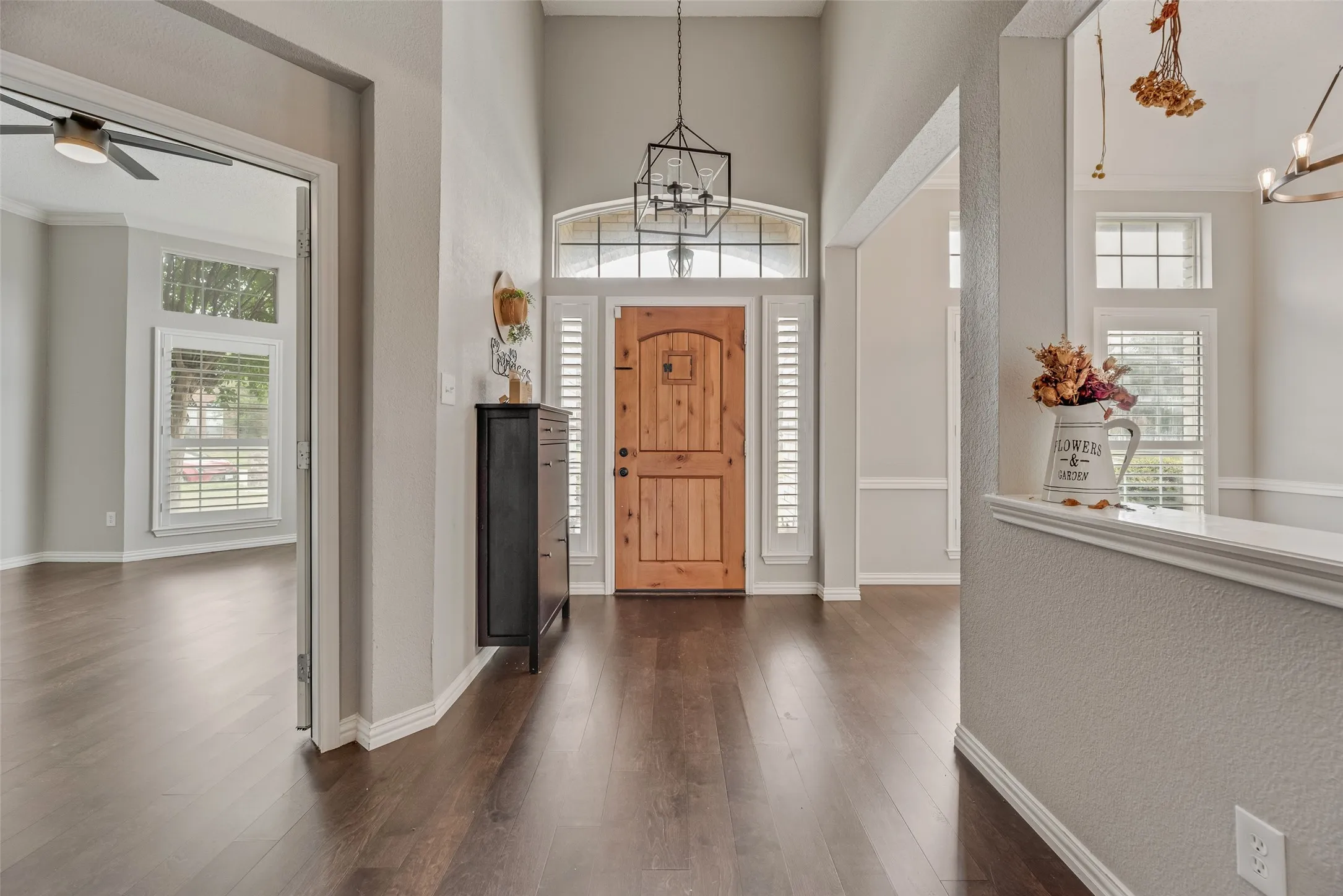 Vaulted entryway featuring a wood front door, transom window, and wood-finish flooring