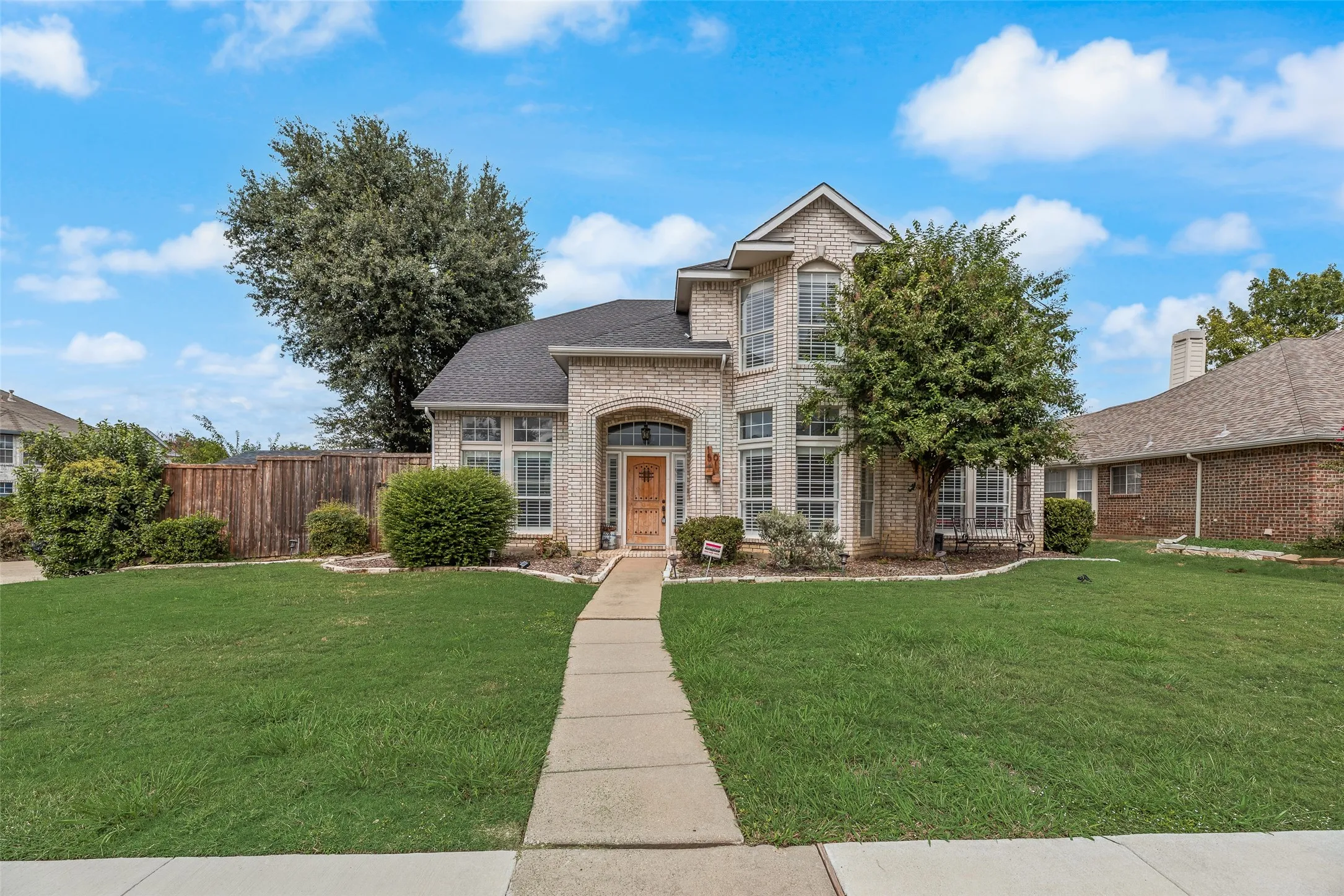 Brick exterior with arched entry, gabled roof, and multiple window styles