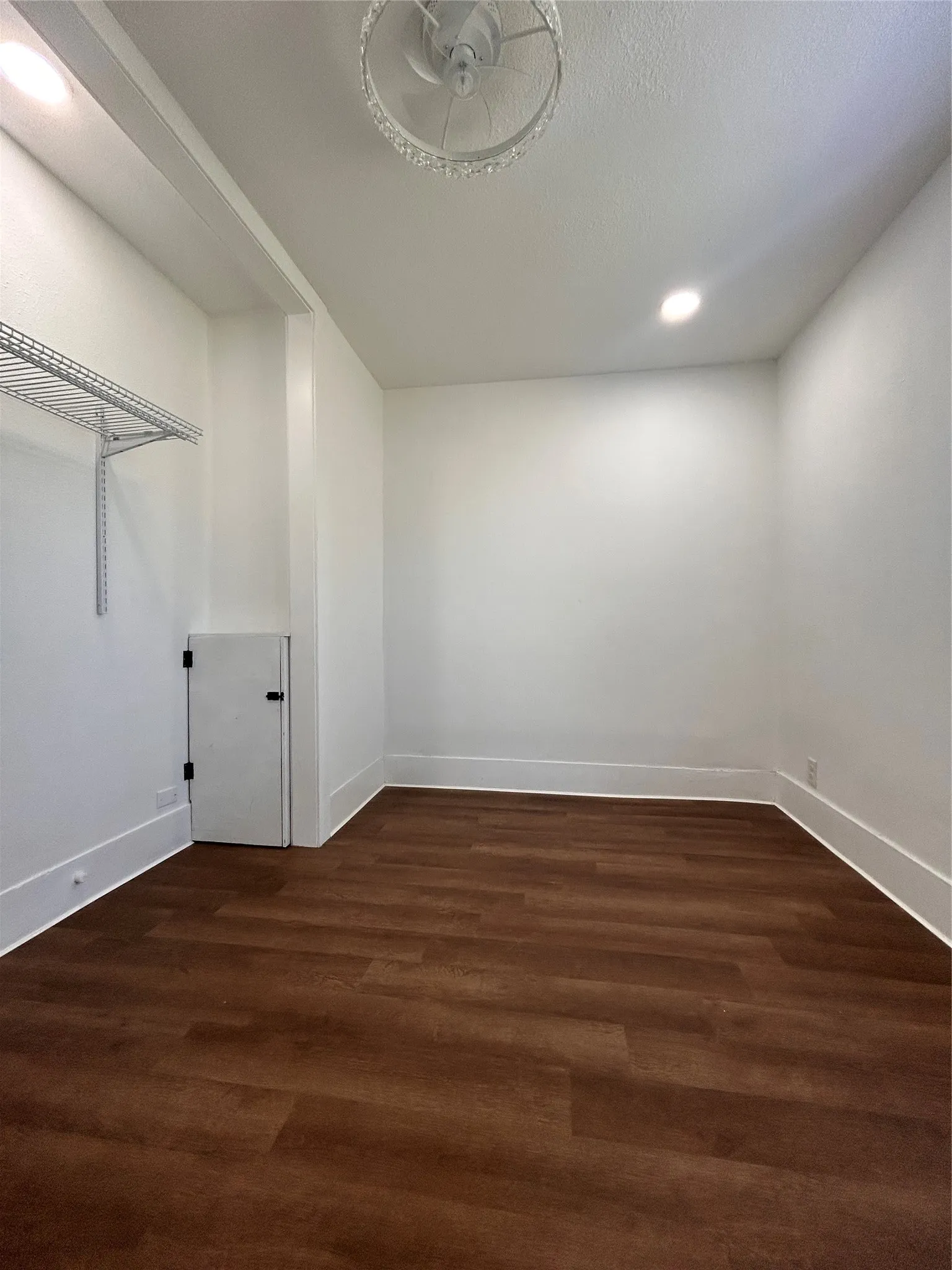 3rd bedroom or an office space. Wood-finish flooring, white walls, recessed ceiling lighting, and a decorative semi-flush mount fixture