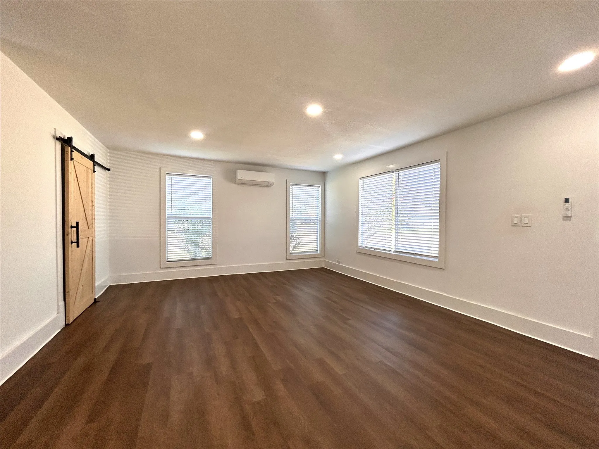 Wood-finish flooring throughout, recessed lighting, and multiple windows with blinds