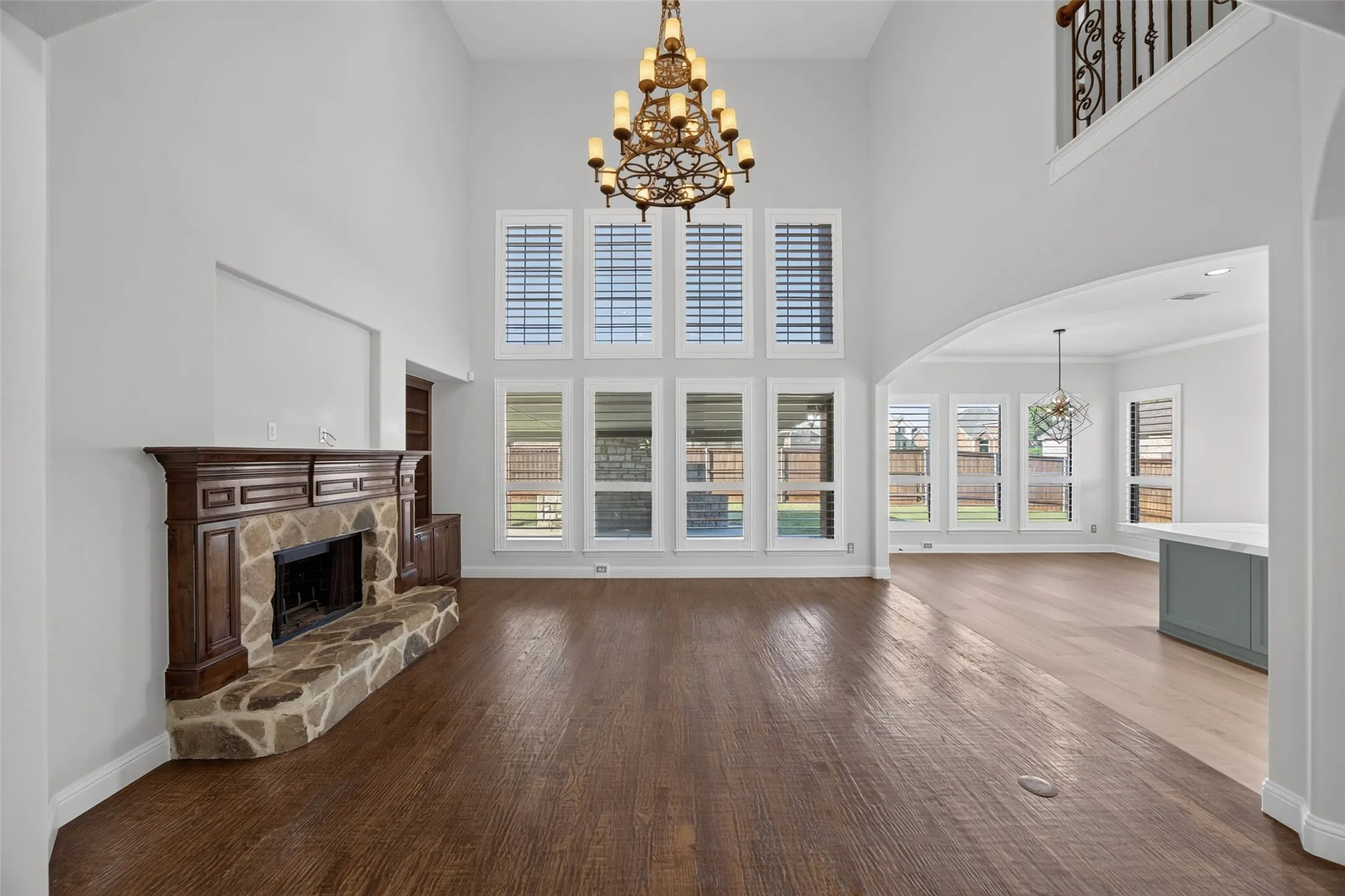 Two story living room, gorgeous windows with expensive custom shutters and pretty wood burning fireplace with gas starter
