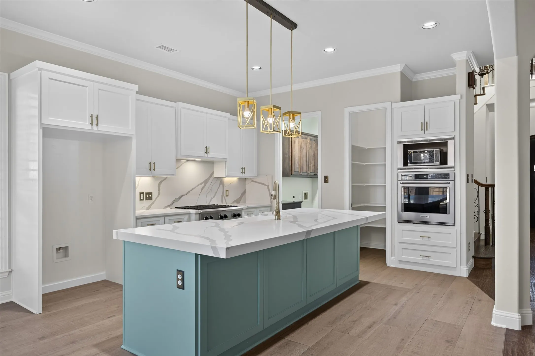 Beautifully updated kitchen in 2022 boasts gas cooktop, breakfast island, quartz counters, stainless appliances, designer lighting and walk-in pantry