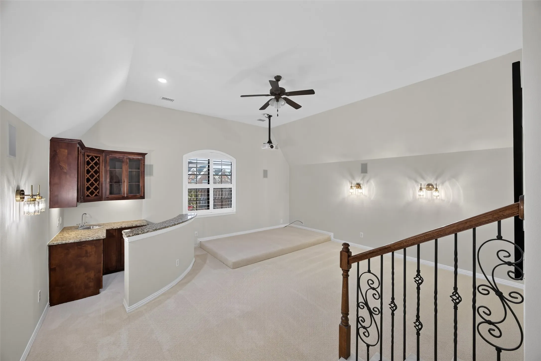 Media room features multi-level seating area, kitchenette with wet bar and theatre lighting.