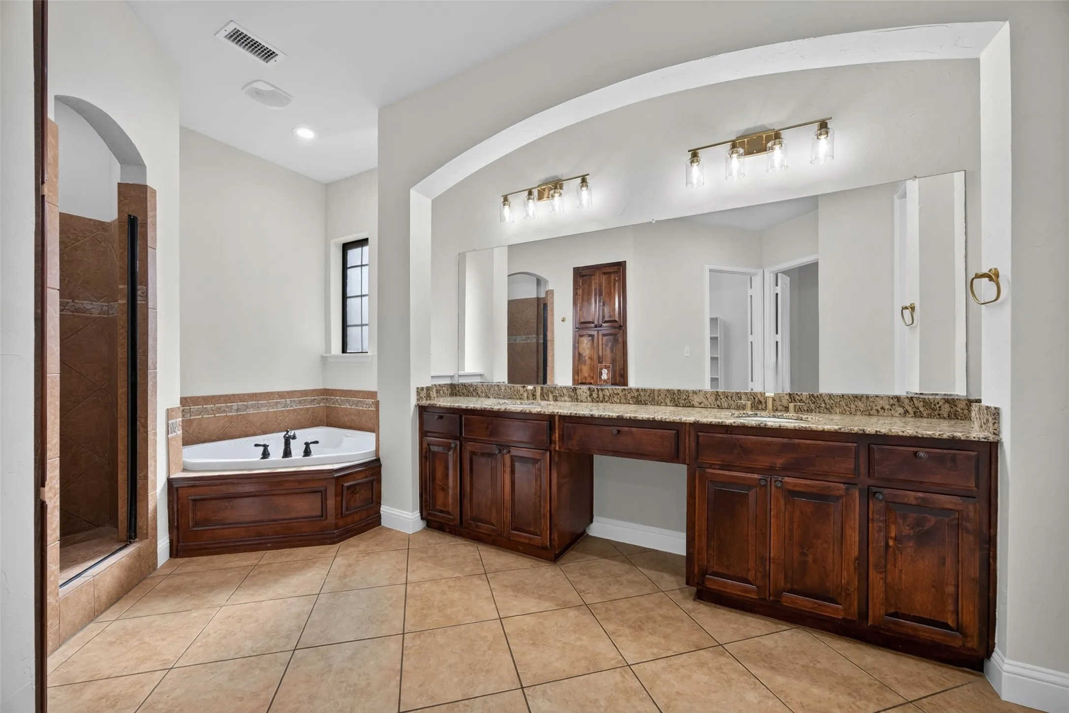 Large primary bathroom has double sinks, jetted bathtub and private shower, PLUS a fabulous walk-in closet!