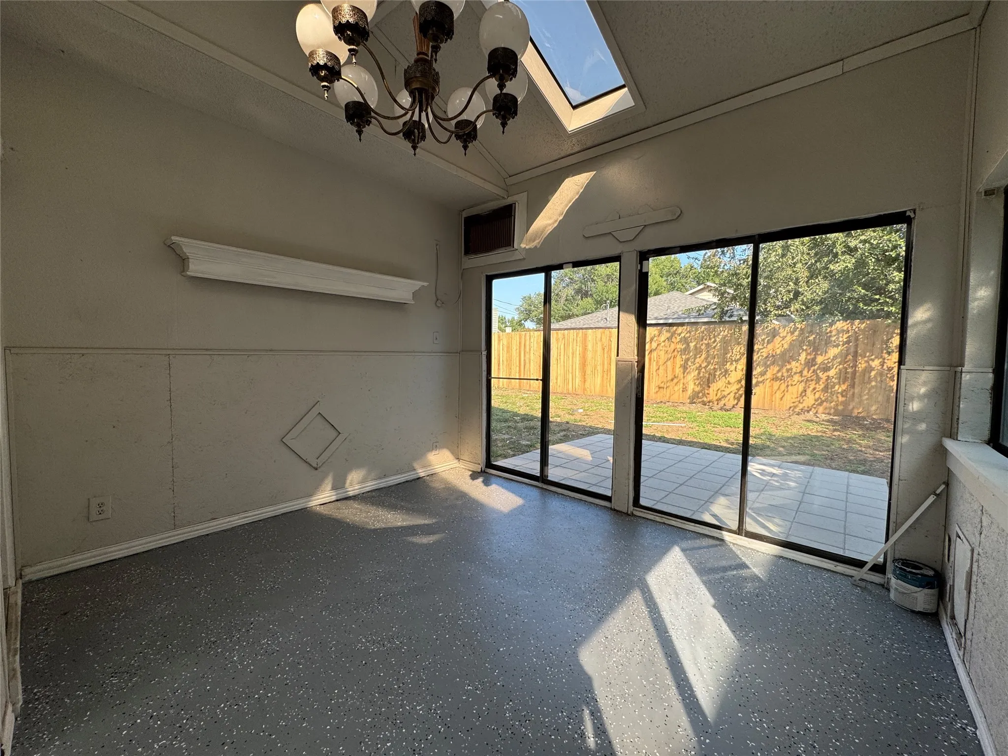 Vaulted ceiling, skylight, chandelier, epoxy flooring, sliding glass doors