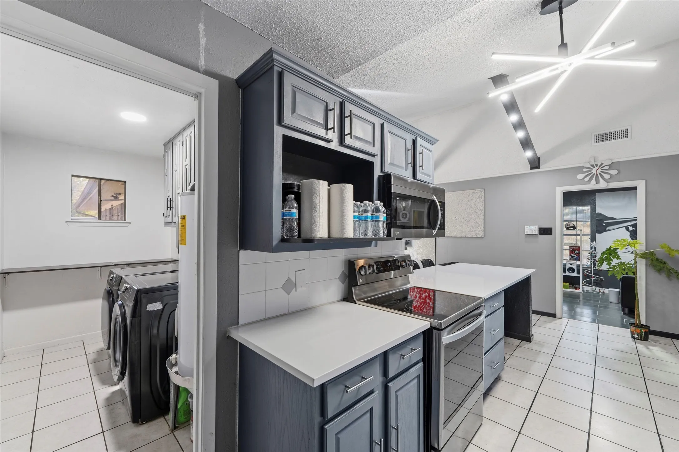 Kitchen with gray cabinetry, stainless steel appliances, and white countertops