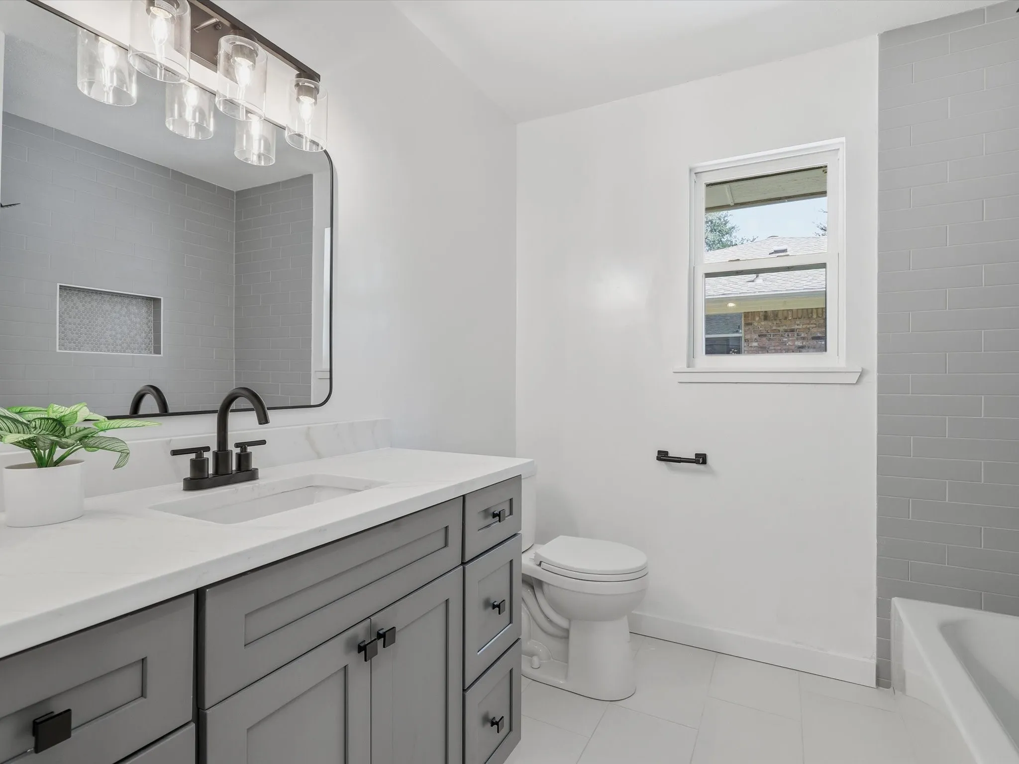 Vanity with quartz countertop, undermount sink, and matte black faucet