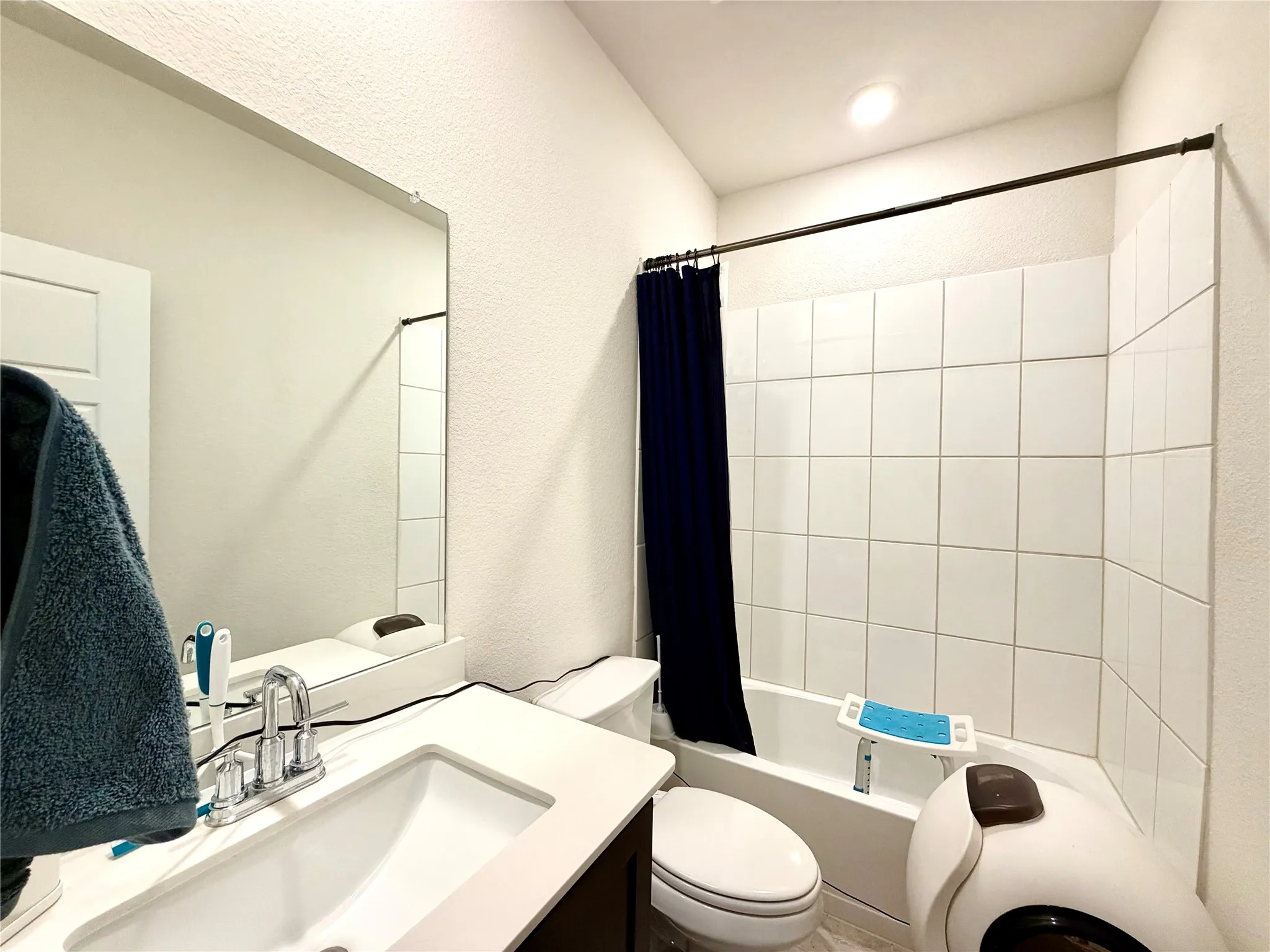 Bathroom featuring a vanity with an integrated sink, polished chrome faucet, and a wall-mounted mirror