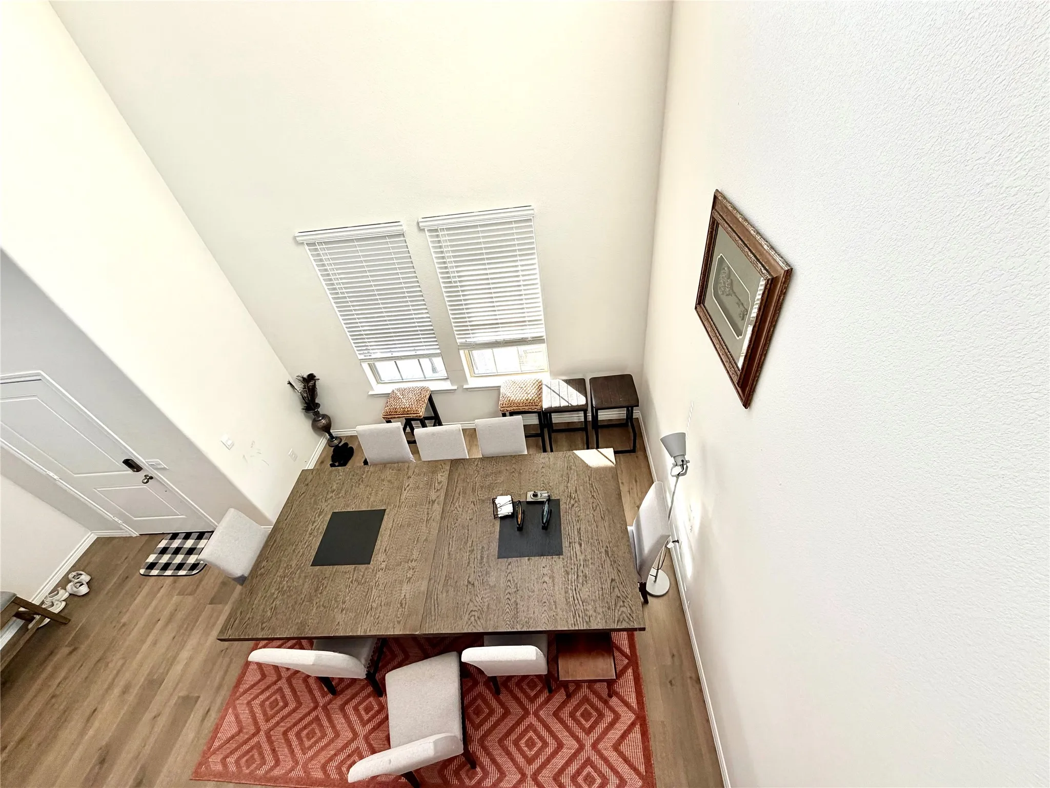 Vaulted ceiling with dual windows, wood-finish flooring, and white interior doors