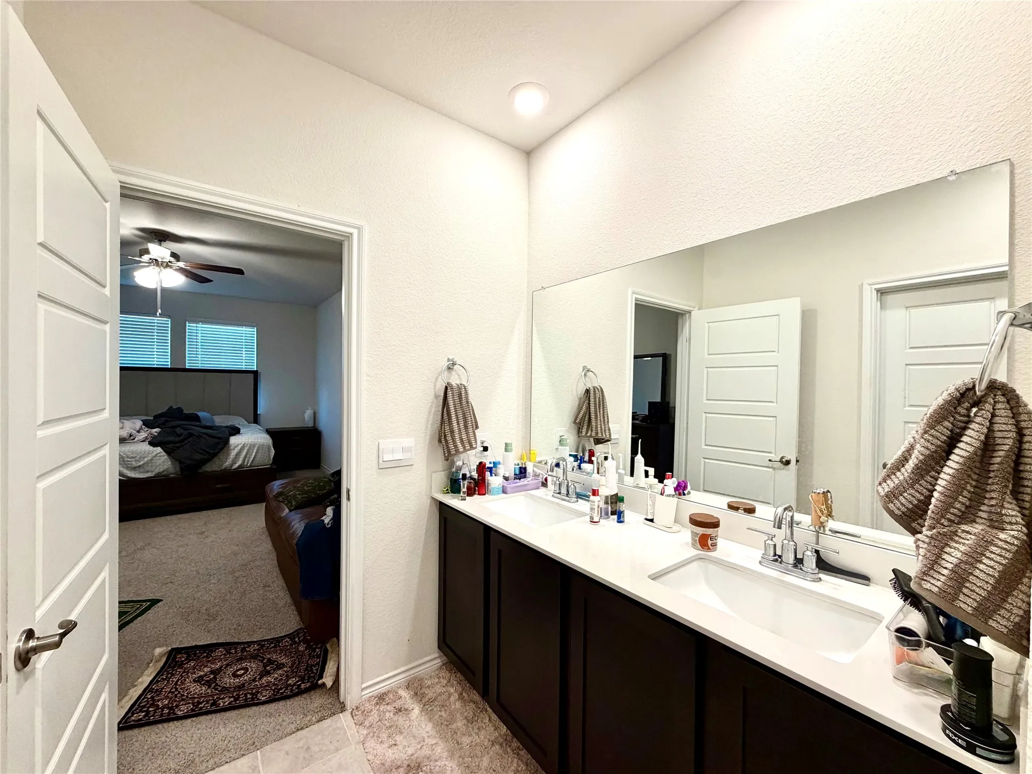Dual vanity with white undermount sinks, chrome fixtures, and a large wall-mounted mirror