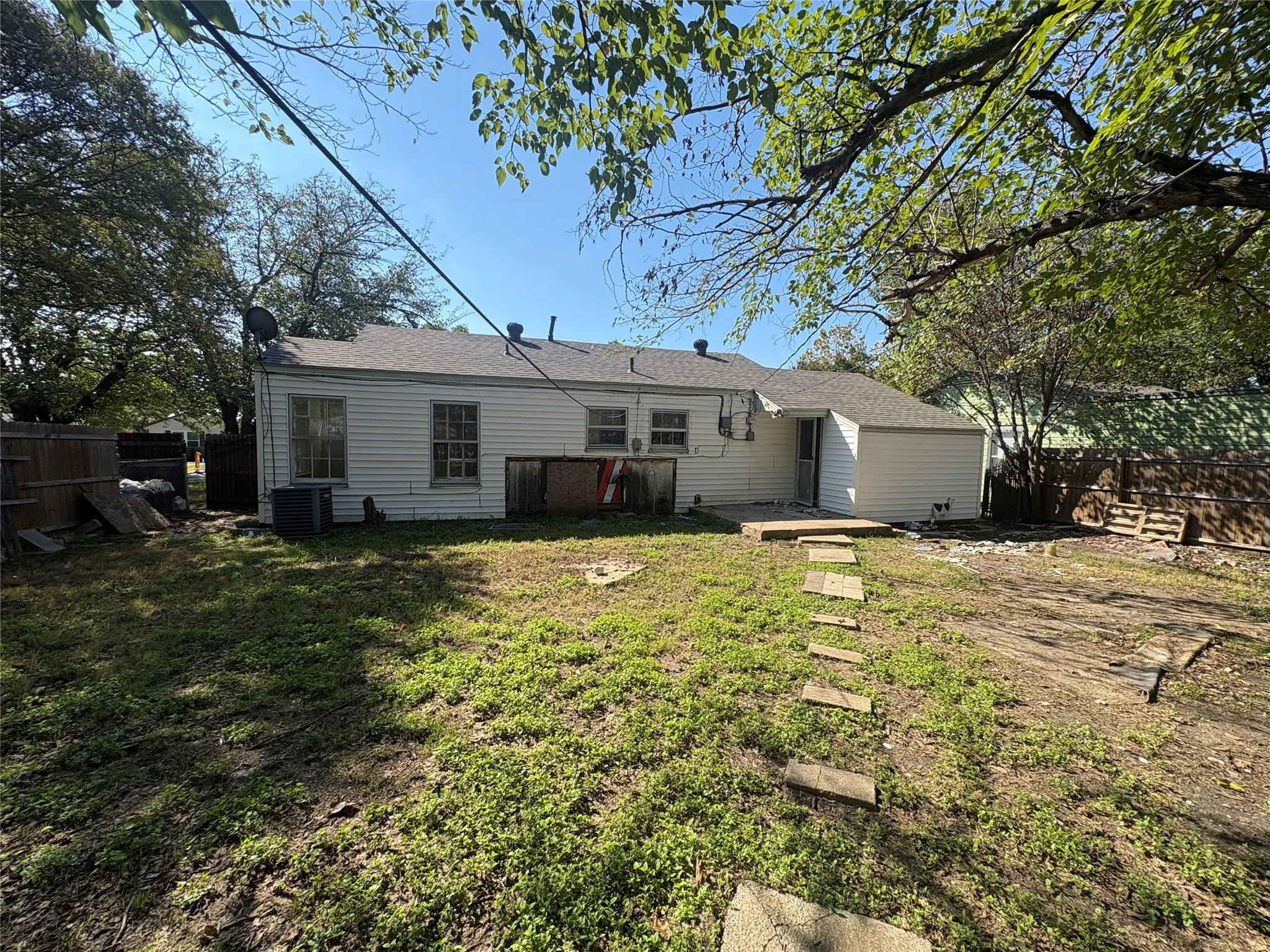 Rear exterior with white siding and a patio with stepping stones
