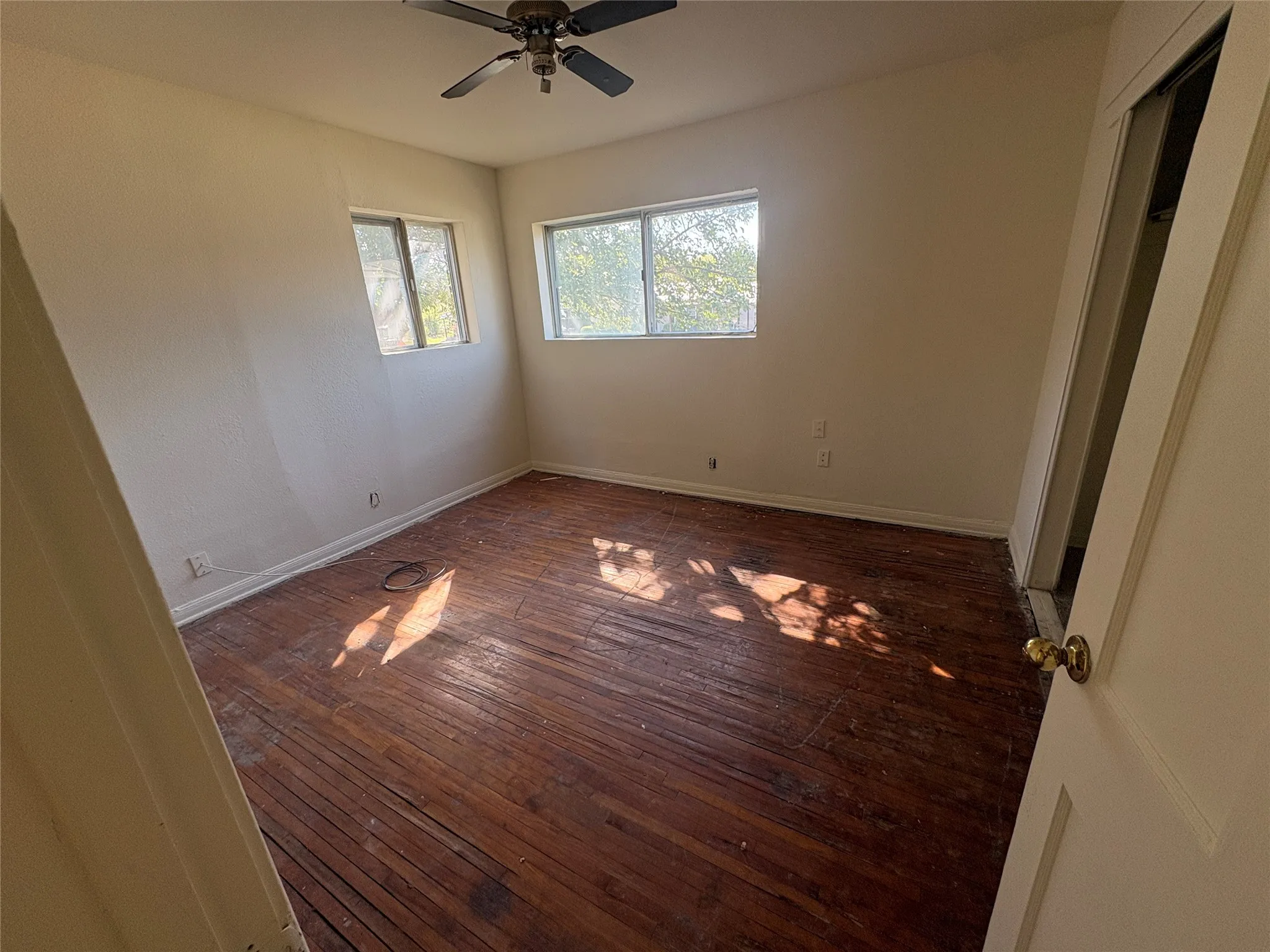Hardwood flooring, dual windows, ceiling fan, and built-in closet