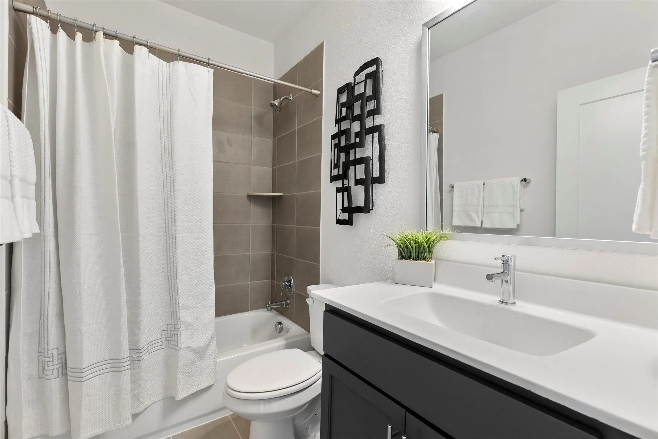 Well-appointed secondary bathroom that includes modern fixtures, ample vanity storage, and tasteful finishes throughout, providing a comfortable space for family and guests alike.