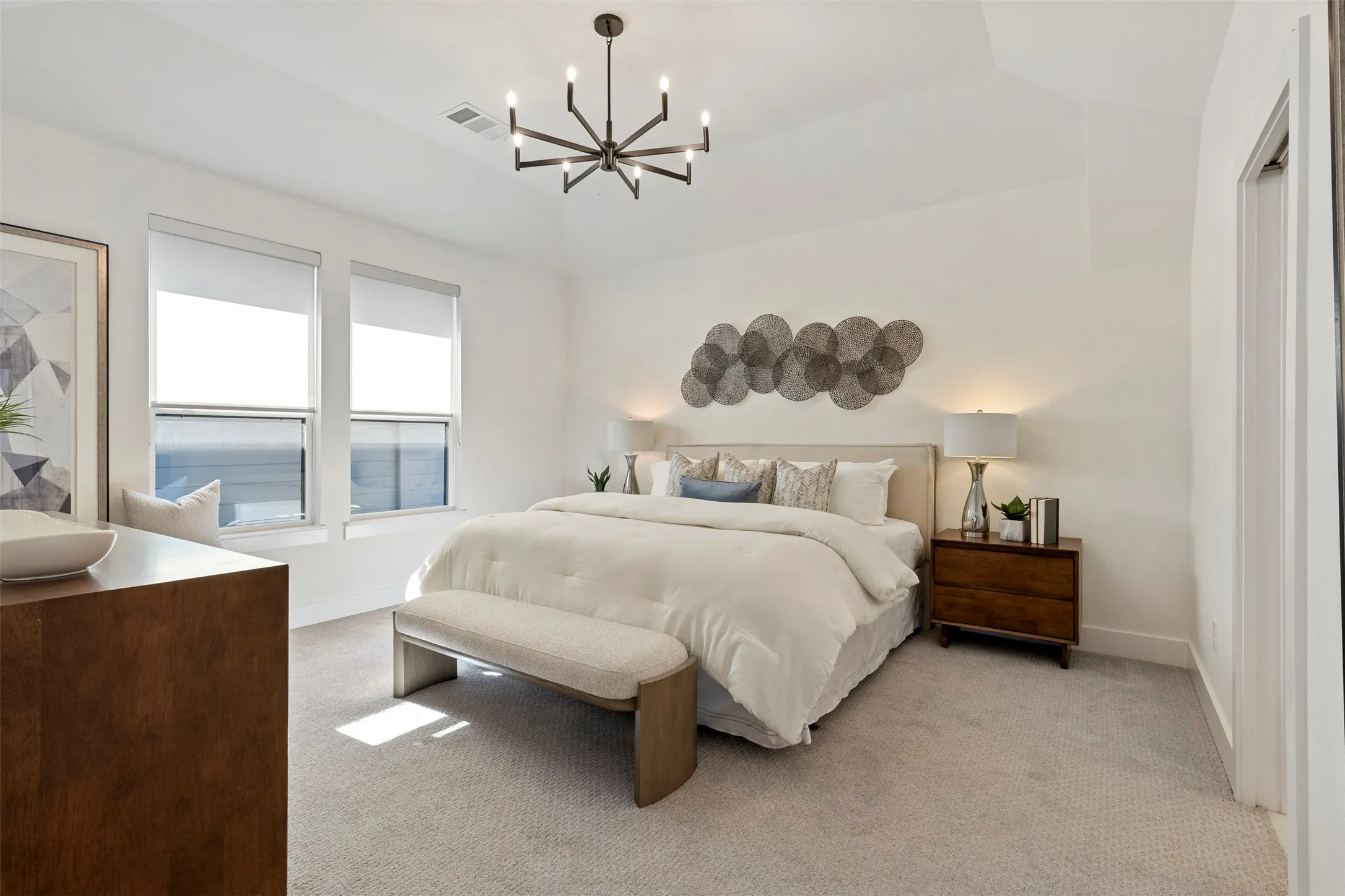 This primary bedroom suite features a remarkably spacious and open floor plan, complemented by high-end ensuite facilities and luxury finishes designed to offer a serene and private retreat within the home.