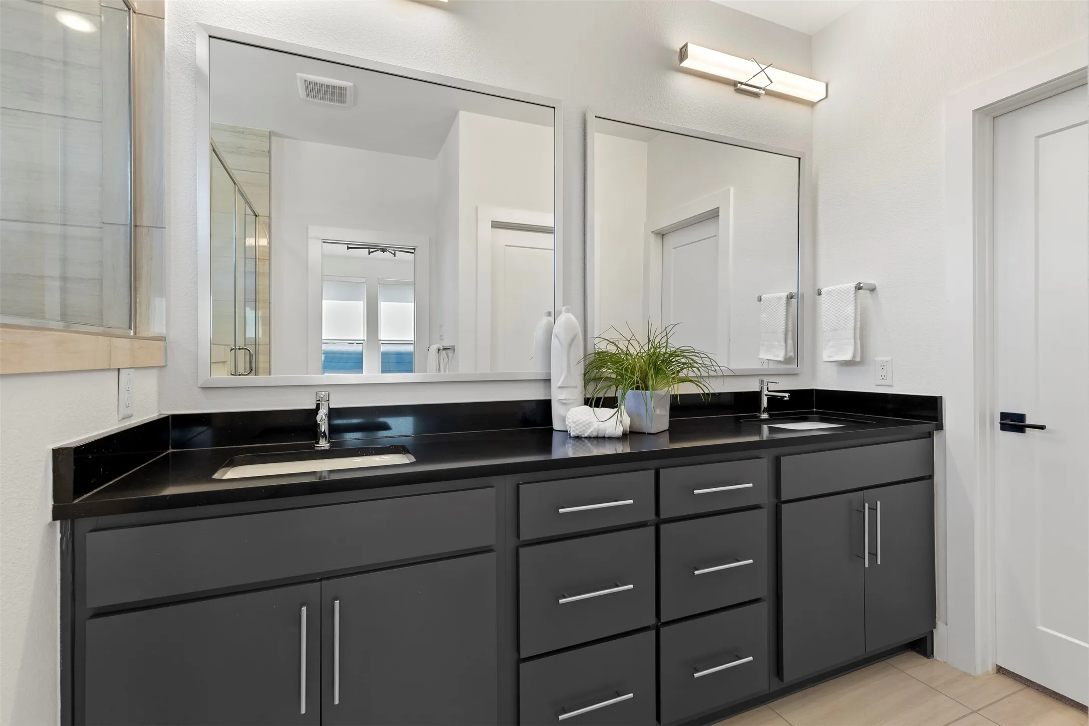 This primary bathroom features a sophisticated dual vanity design paired with an exceptionally spacious walk-in closet, offering the perfect combination of luxury and high-capacity storage that is certain to leave a lasting impression on prospective buyers.