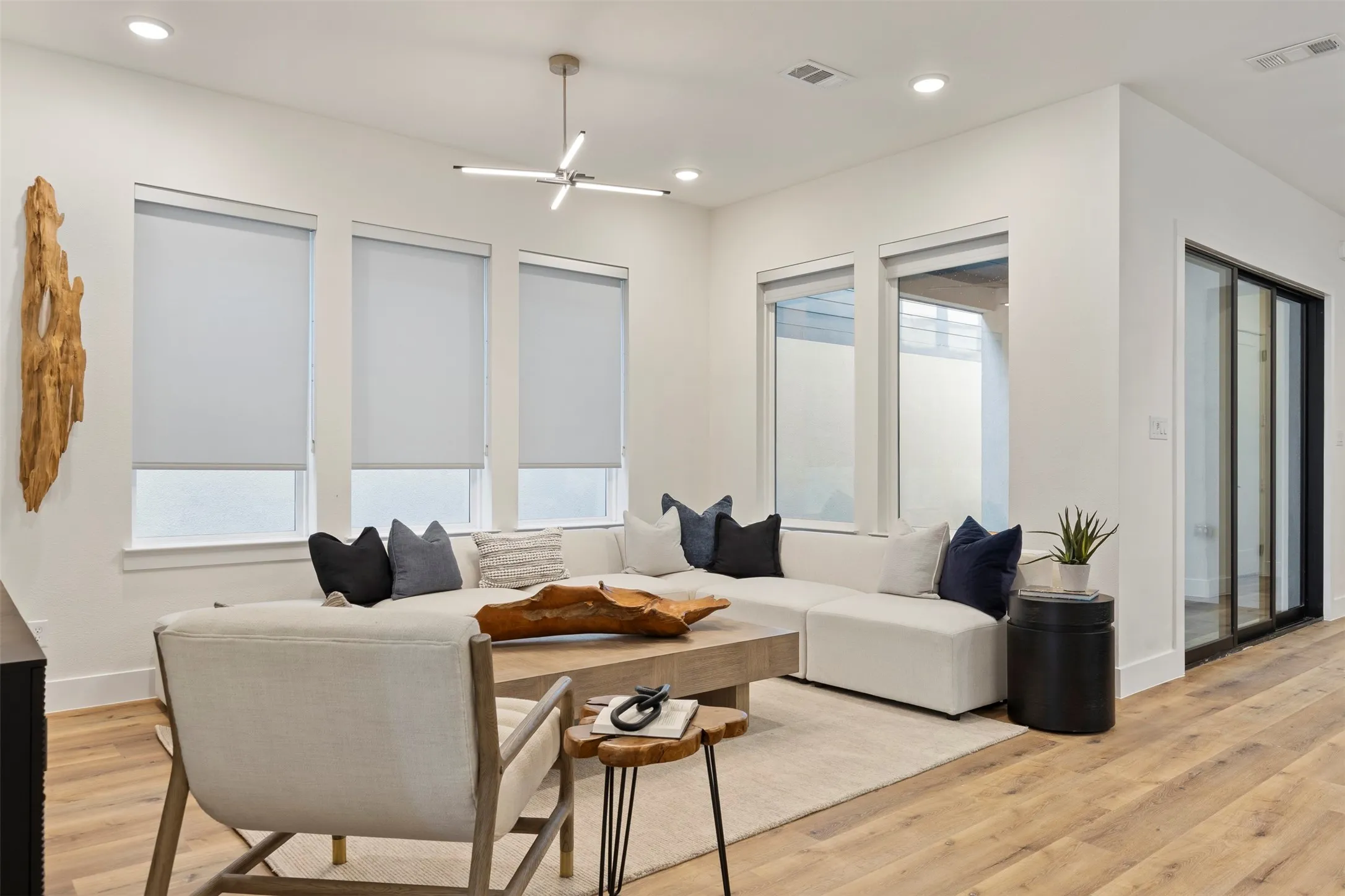 Natural light fills this living space, highlighting the spacious open-concept floor plan and the warm, neutral color palette that complements the home's contemporary finishes.