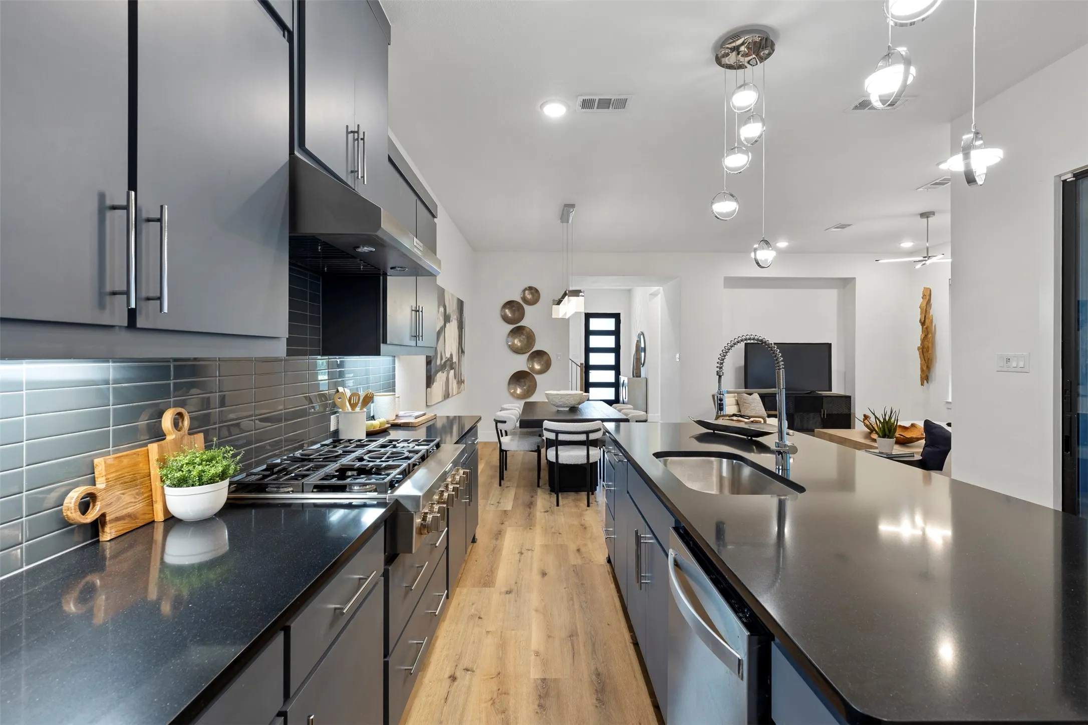 This kitchen is highly functional and designed with an open-concept feel, featuring an abundance of custom cabinet storage to keep all your culinary essentials organized and a generous, expansive counter area that provides plenty of space for meal preparation, casual dining, or entertaining guests.