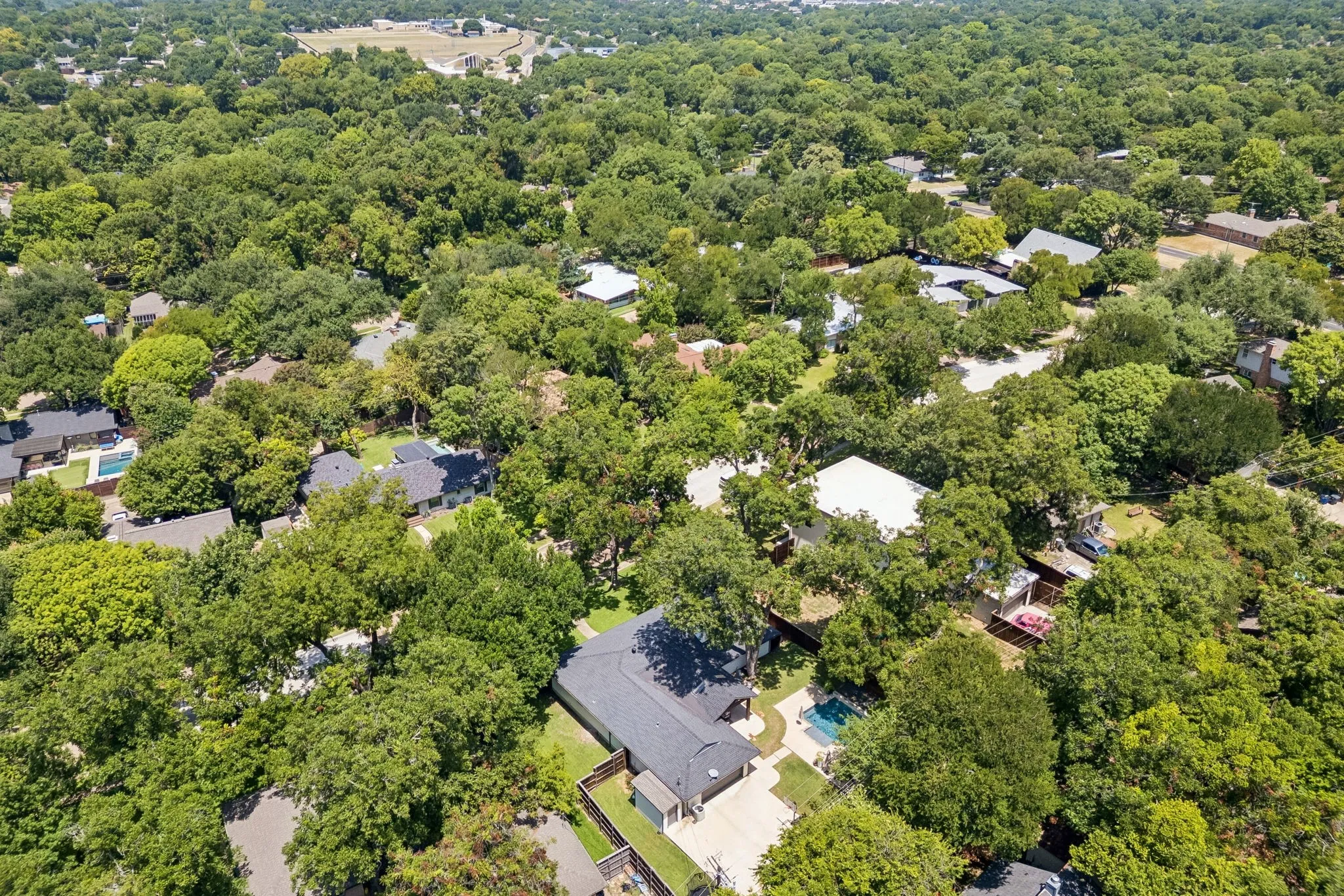 Expansive residential area featuring numerous mature trees and a swimming pool