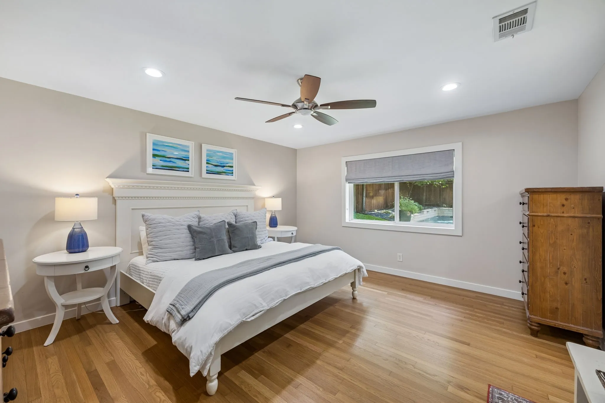 Hardwood flooring, recessed lighting, ceiling fan, window with backyard pool visibility, and neutral wall tones