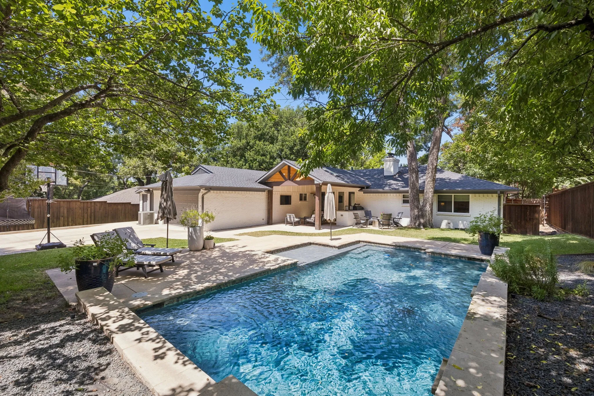 Rectangular swimming pool with integrated spa and stone coping