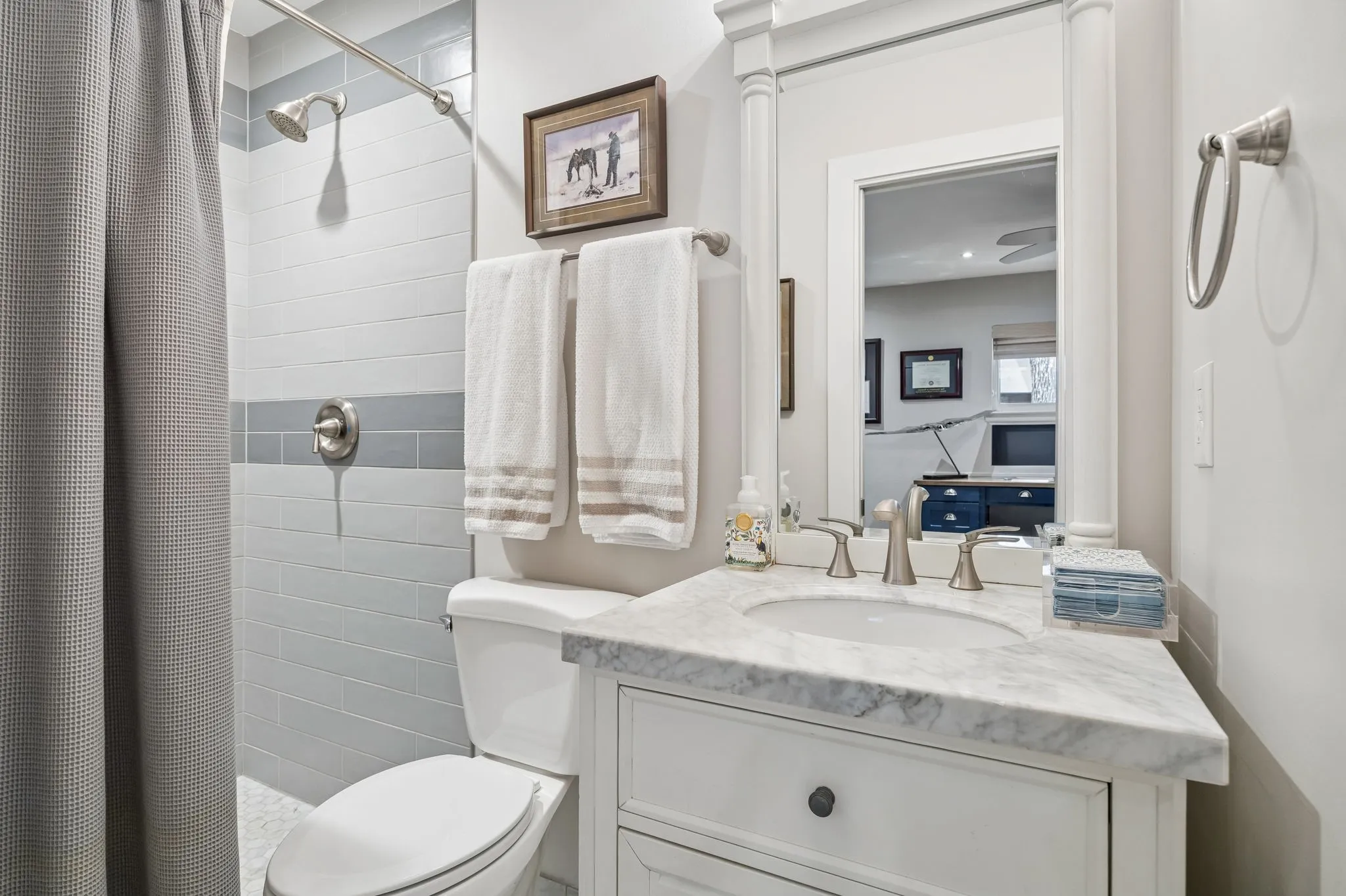 Vanity with a marble-finish countertop, undermount sink, and brushed nickel fixtures