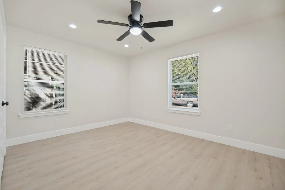 Recessed lighting, wood-finish flooring, and a ceiling fan with integrated lighting