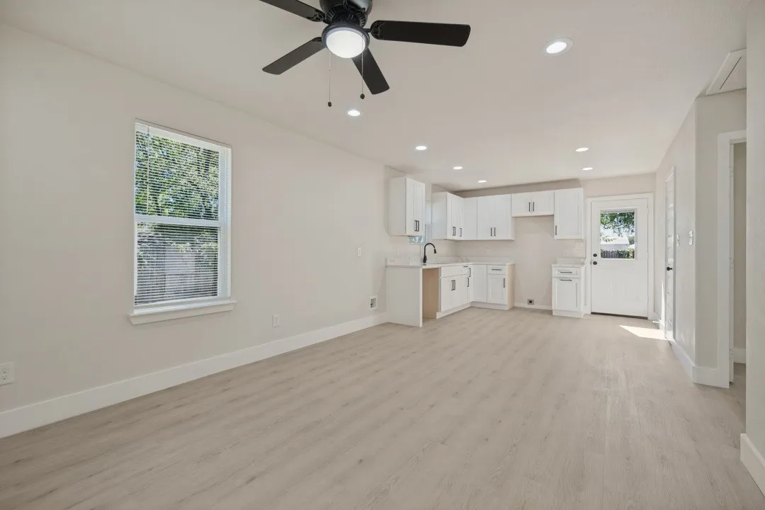 Open-concept living space featuring wood-finish flooring, recessed lighting, and a ceiling fan