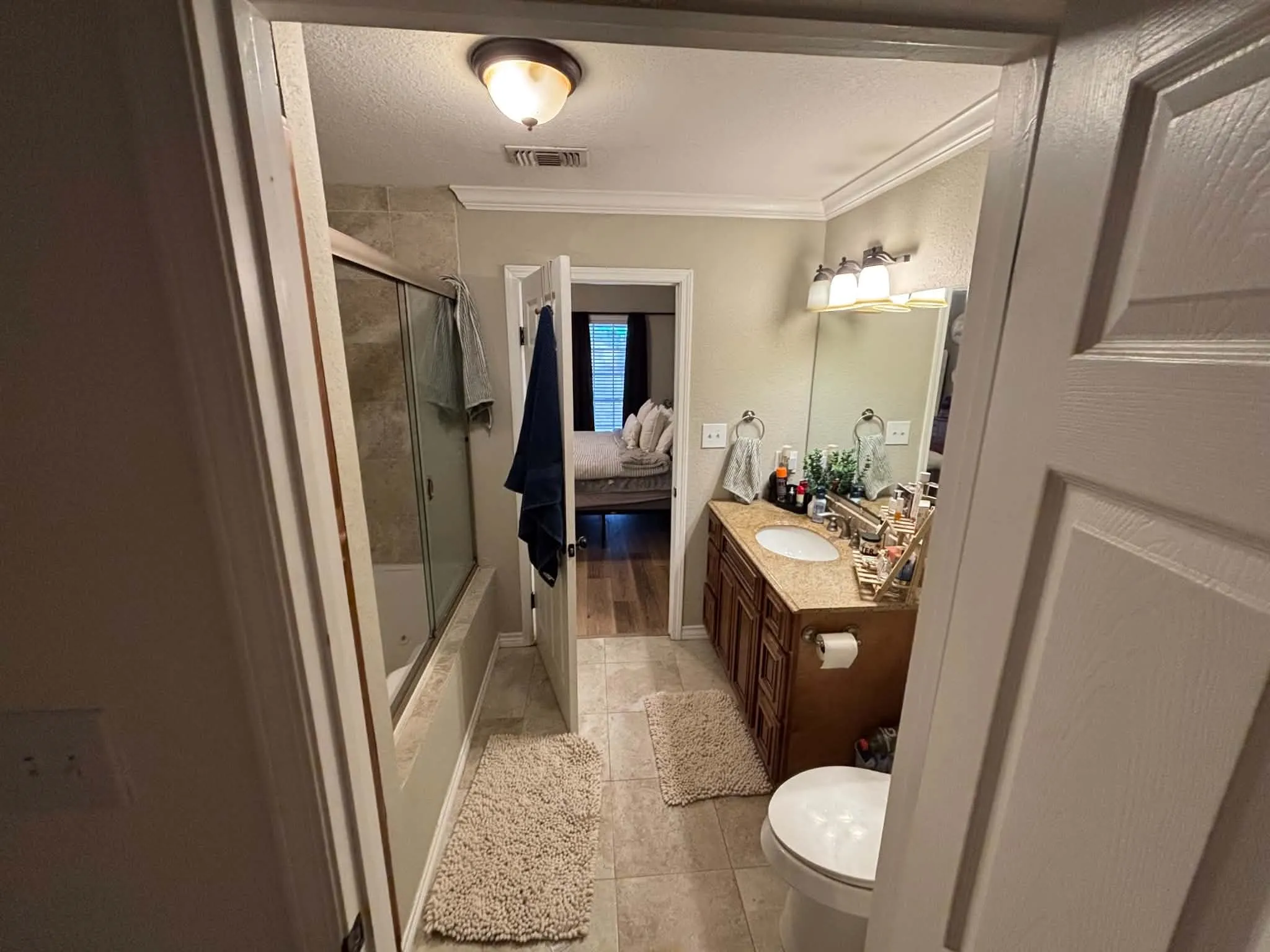 Bathroom featuring a built-in vanity with a stone-finish countertop, under-mount sink, and a framed mirror