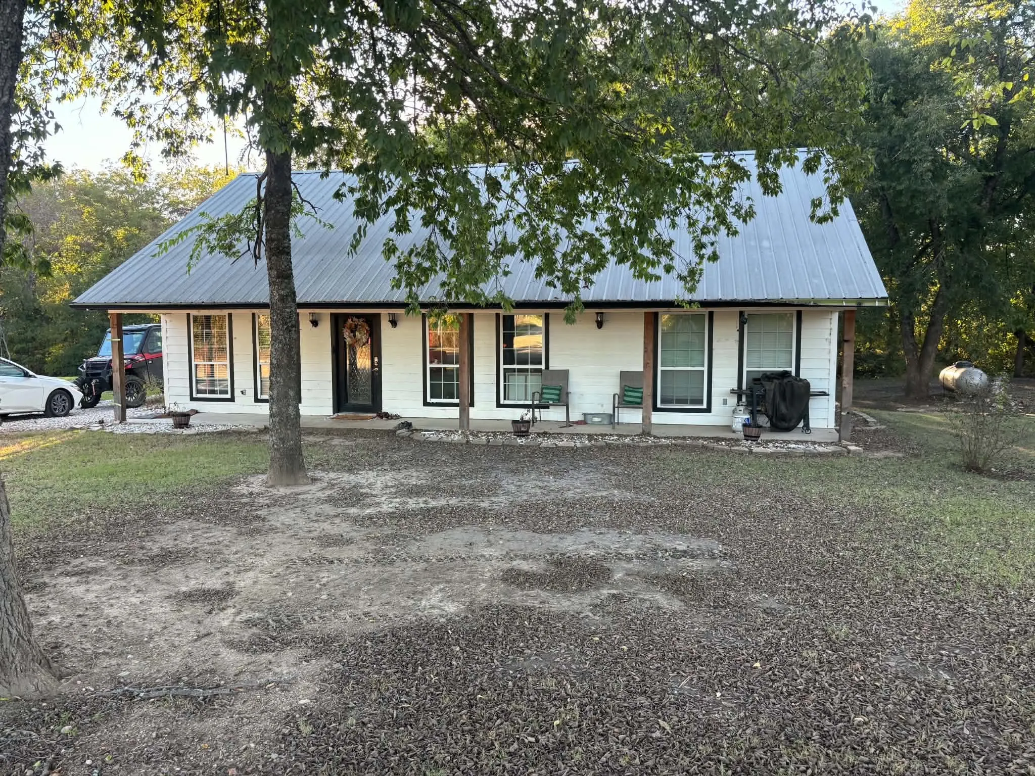 White siding exterior with a dark metal roof