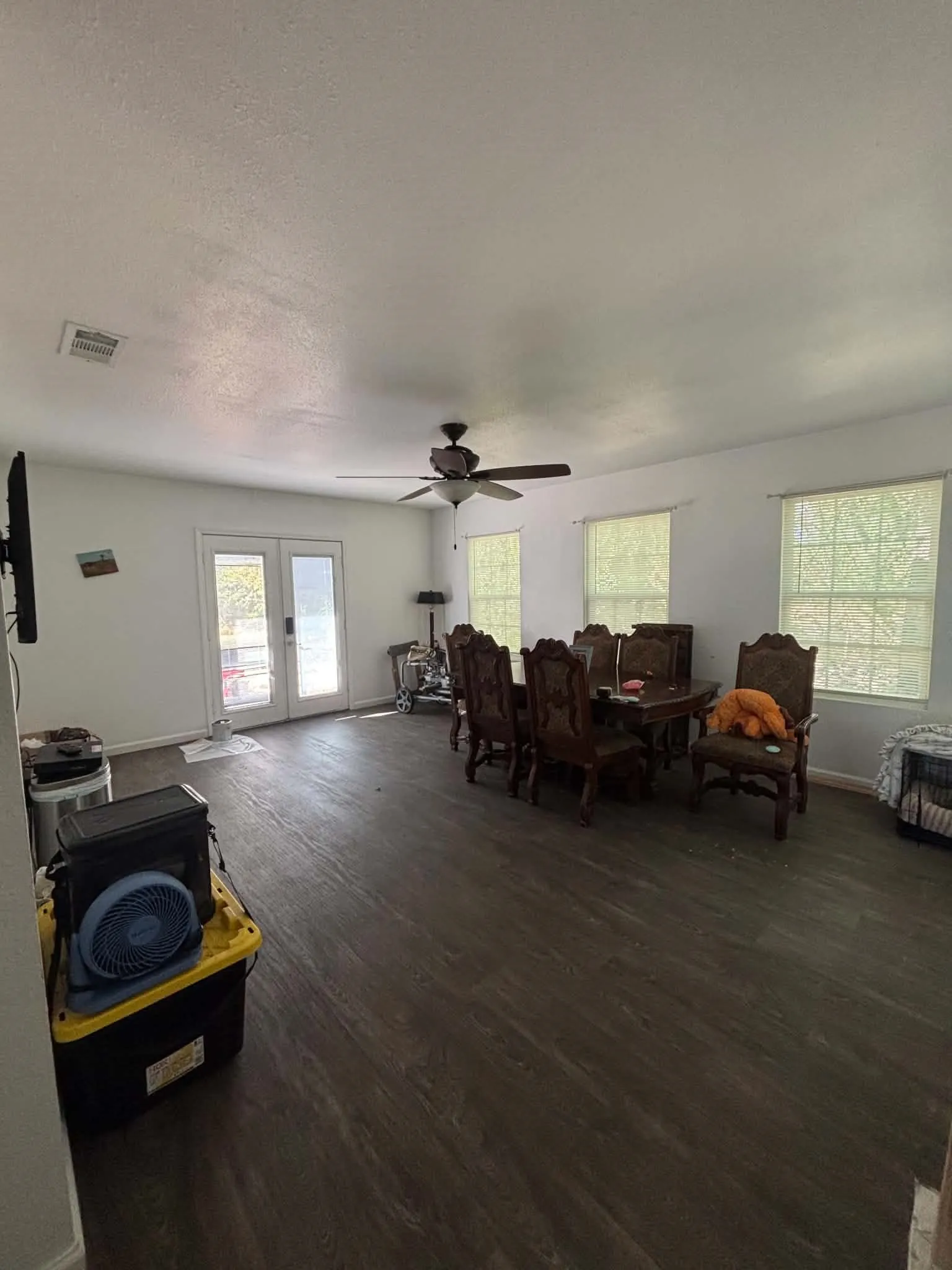 Spacious interior with wood-finish flooring, white walls, and a ceiling fan