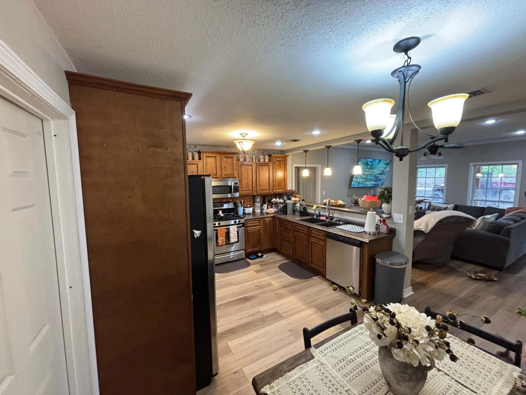 Expansive kitchen featuring wood cabinetry, stainless steel appliances, and wood-finish flooring