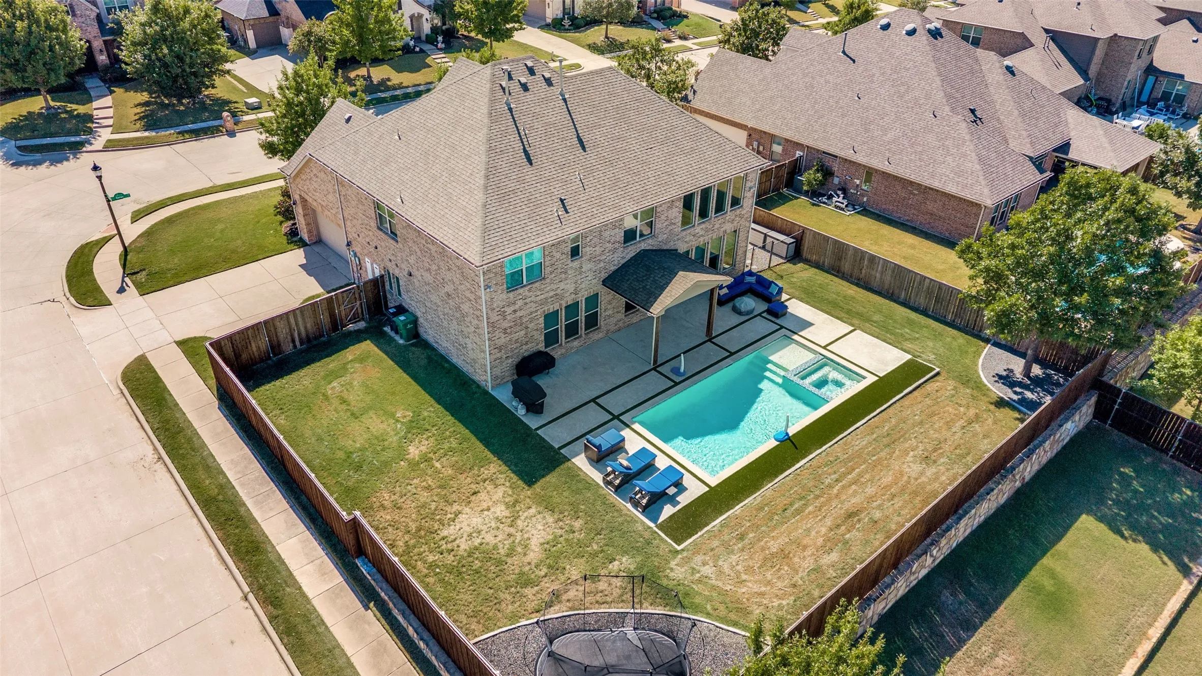 Brick exterior, fenced backyard, in-ground swimming pool, concrete patio, mature tree