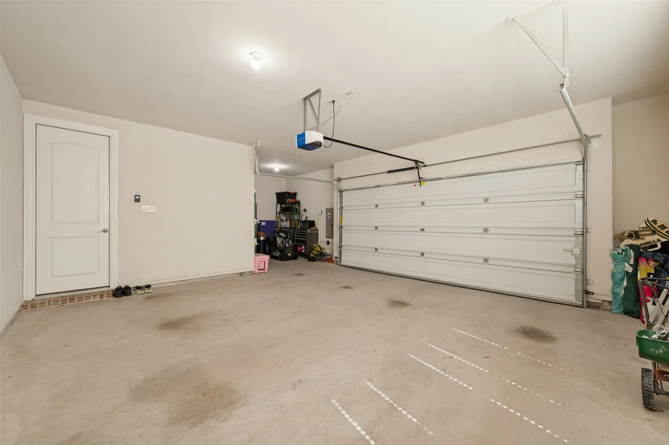 Attached garage with concrete flooring, automatic garage door opener, and a panel door