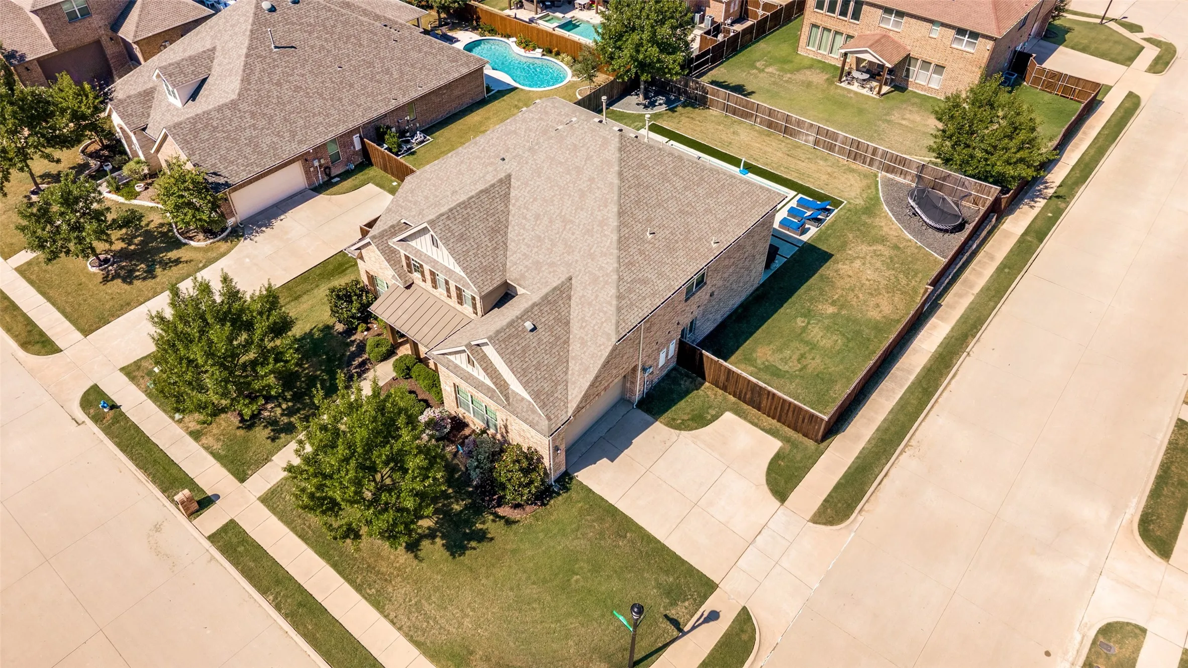 Brick exterior, pitched roof, attached garage, concrete driveway, fenced yard