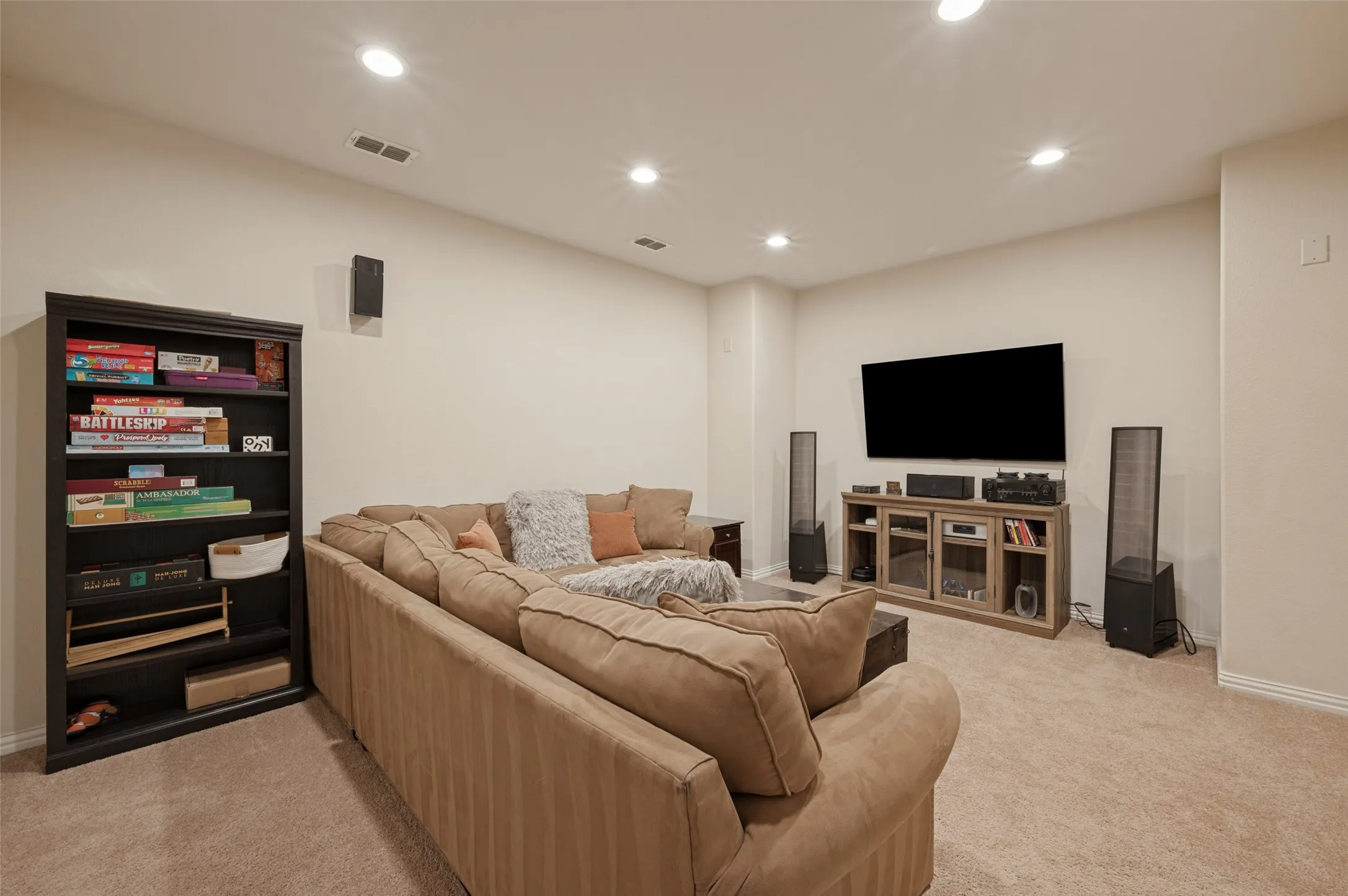 Recessed lighting illuminates this room featuring wall-to-wall carpeting