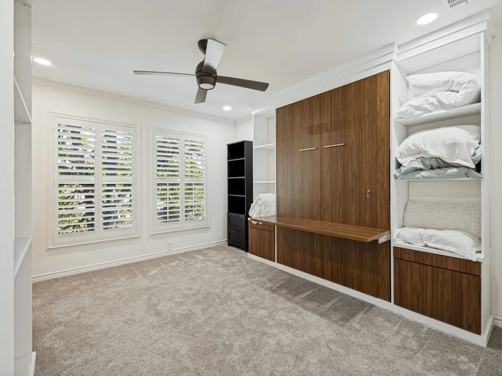Built-in wall unit with wood-finish cabinetry, murphy bed integrated desk, and open shelving