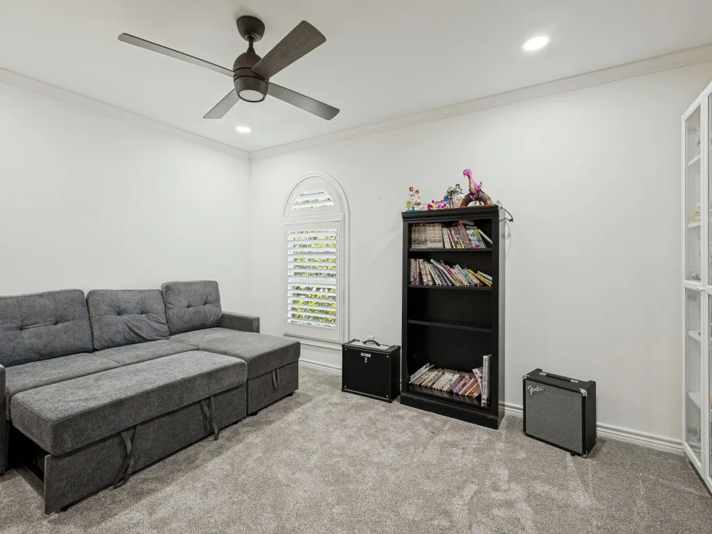 Arched window with plantation shutters, recessed lighting, crown molding, ceiling fan, and carpeted flooring